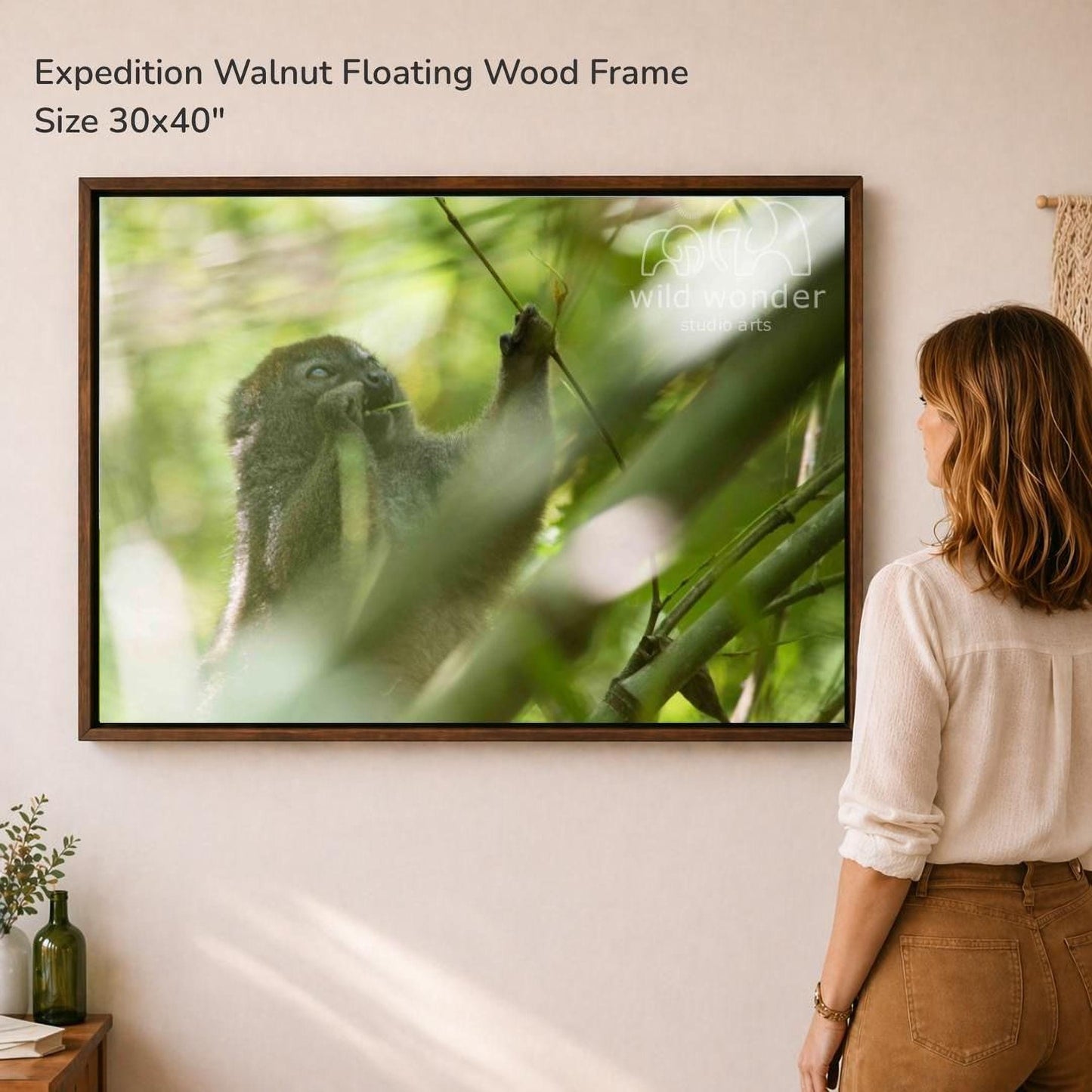 A woman is standing in front of a large framed photograph of a walnut floating in the air, surrounded by lush greenery.