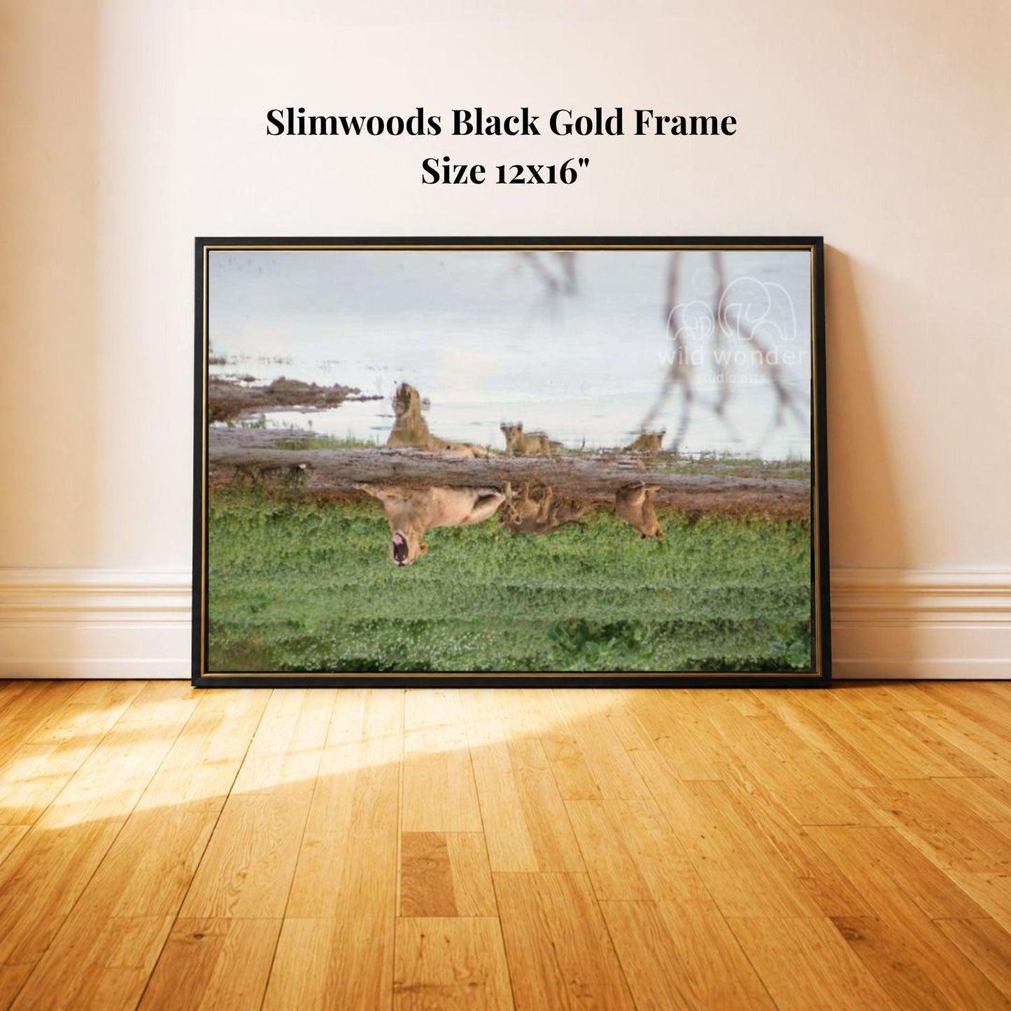 A black gold frame containing a photograph of a group of deer grazing in a grassy field.
