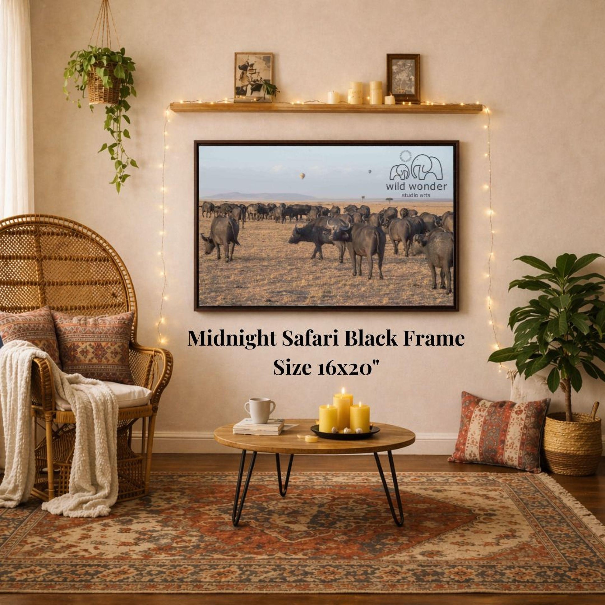a living room with a large framed photograph of a herd of wild animals, specifically a group of elephants, hanging on the wall. The photograph is mounted on a wooden frame, and the wall has a shelf with candles and other decorative items. The room also includes a wicker chair, a coffee table, and a potted plant, creating a cozy and inviting atmosphere.