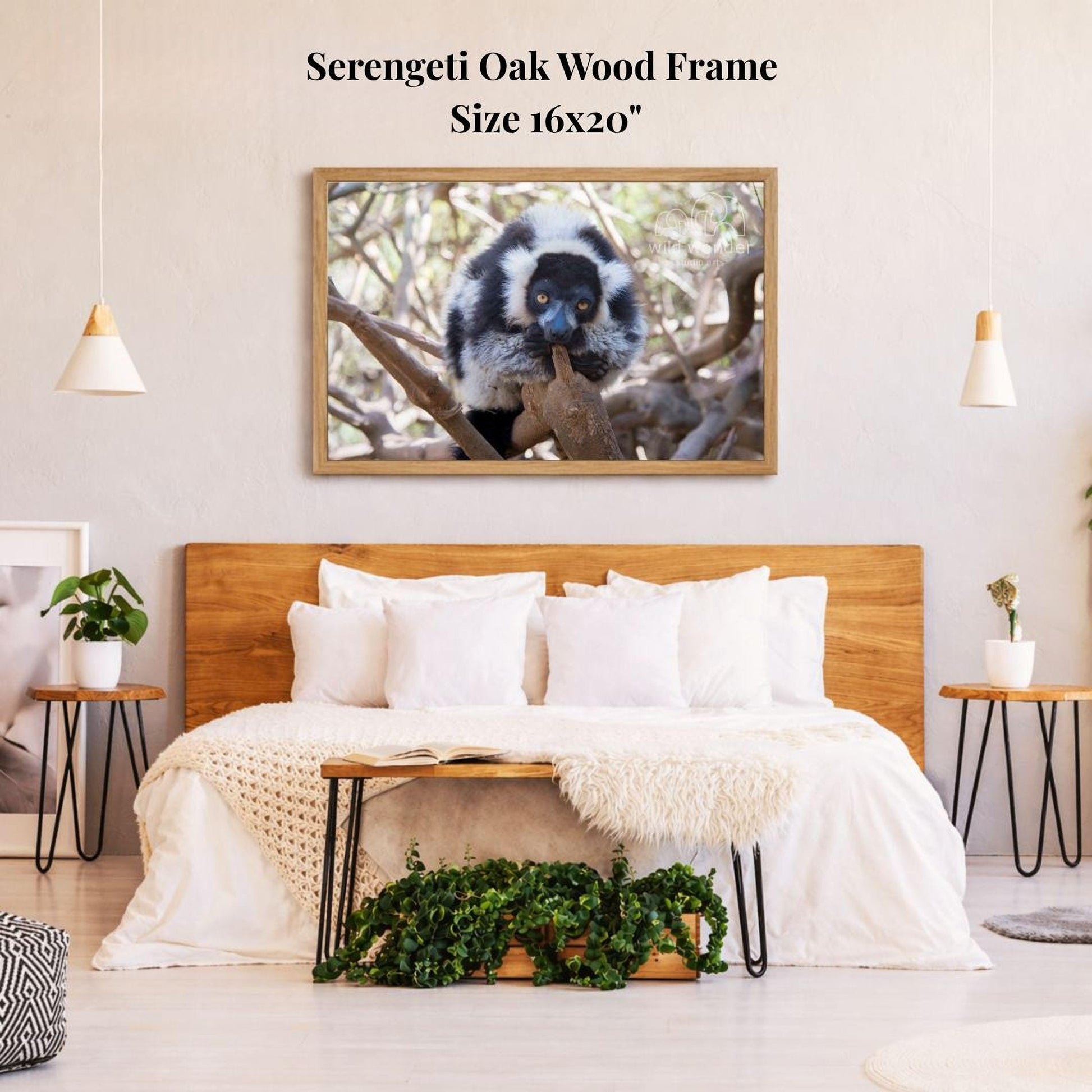 a serene bedroom setting with a large, 16x20" framed photograph of a lemur resting on a tree branch hanging above a bed with white bedding.