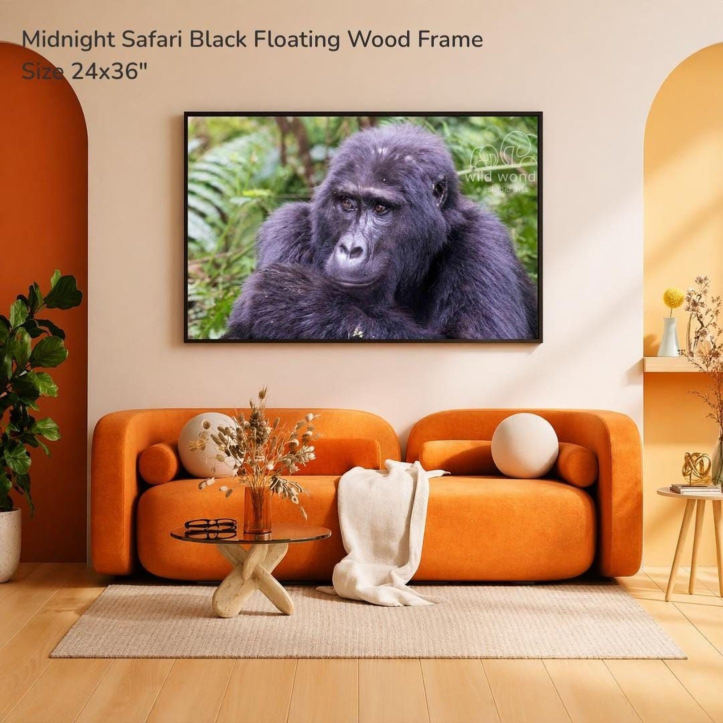 a large black-framed photograph of a gorilla on the wall of a modern living room with an orange sofa, a glass coffee table, and a potted plant.