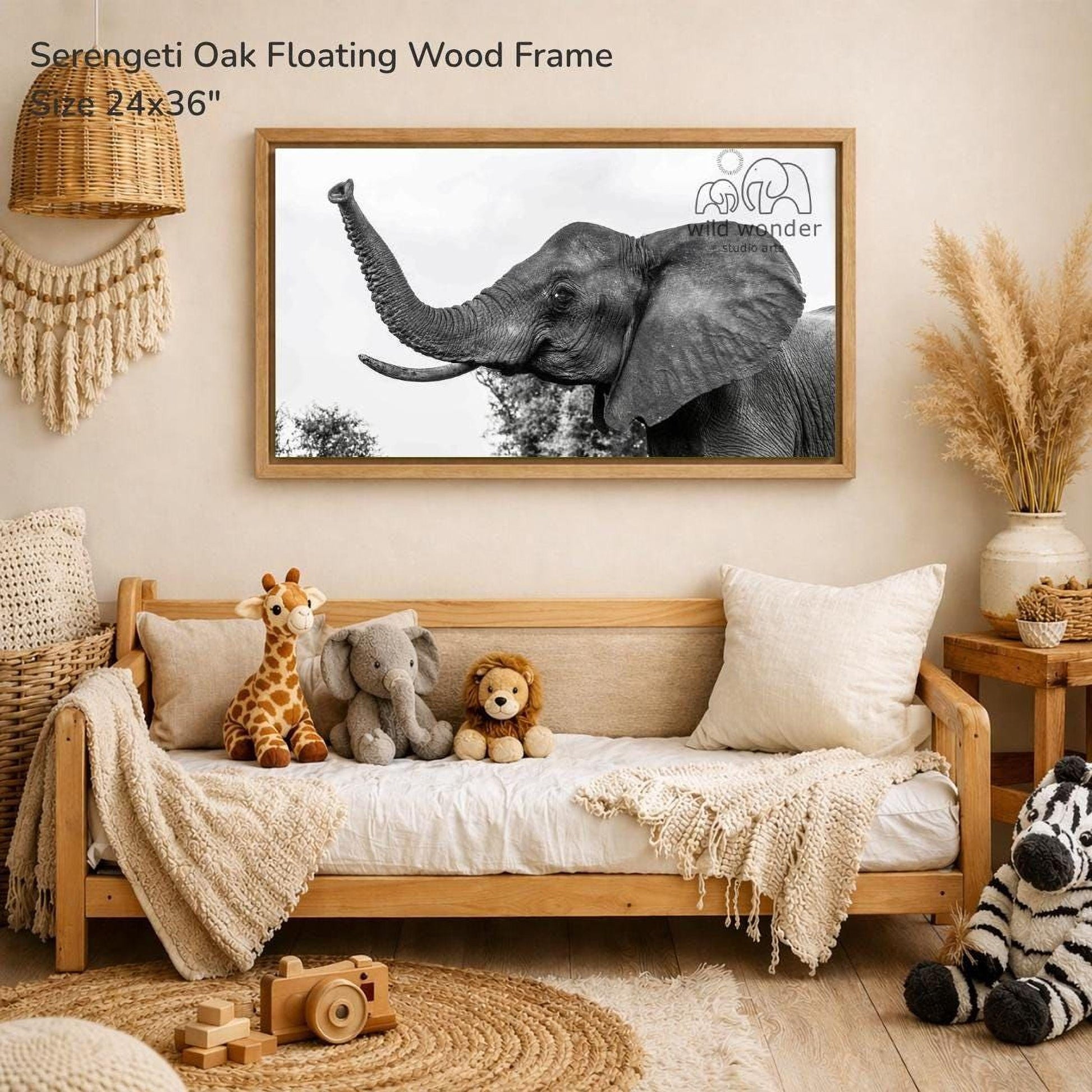 a serene indoor setting with a wooden frame hanging on a wall, displaying a black and white photograph of an elephant. The frame is surrounded by various stuffed animals, including a giraffe, an elephant, and a lion, creating a cozy and playful atmosphere.