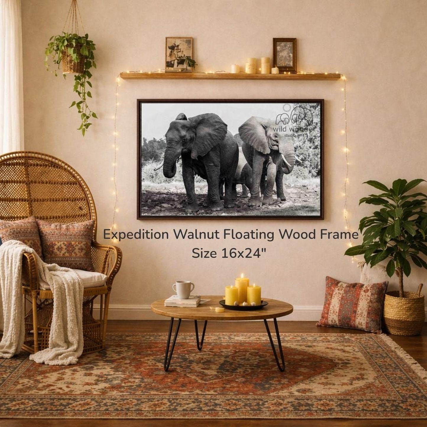 a large black and white photograph of two elephants standing next to each other, hanging on a wall above a coffee table in a cozy living room setting.