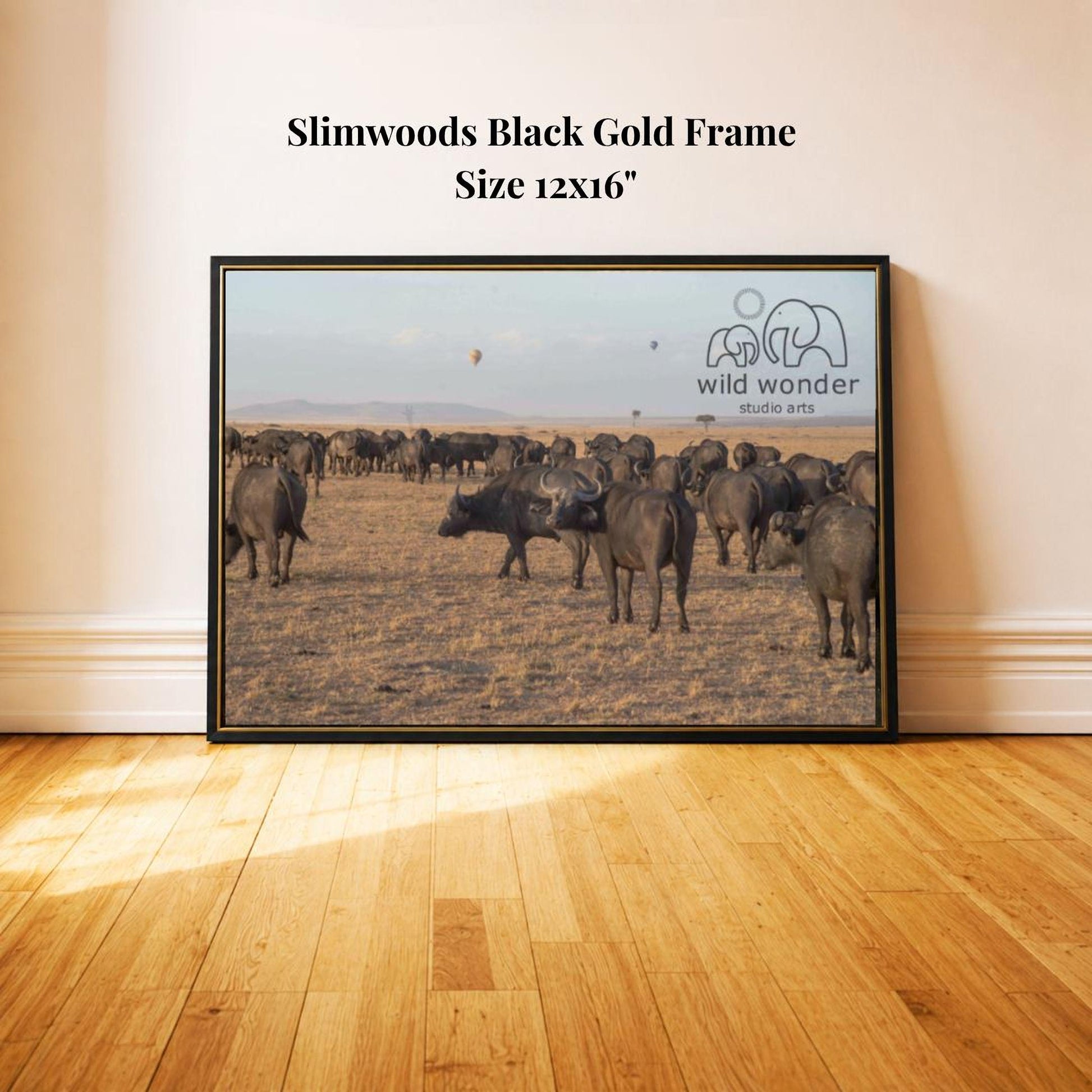 A framed photograph of a herd of wild animals, likely a herd of elephants, in a natural setting.