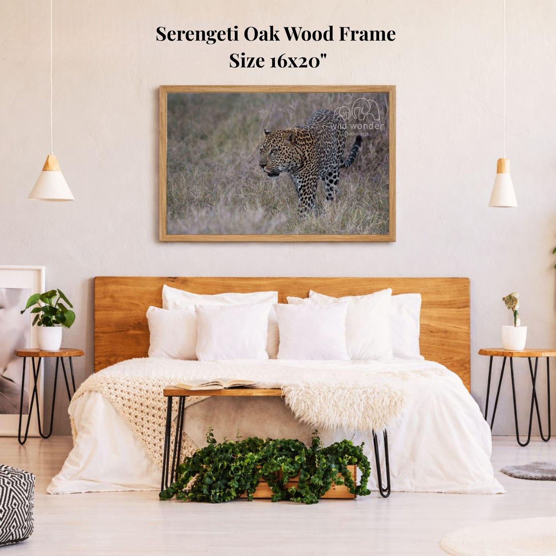 a serene bedroom setting with a large framed photograph of a leopard in the grass hanging on the wall above a bed with white bedding.