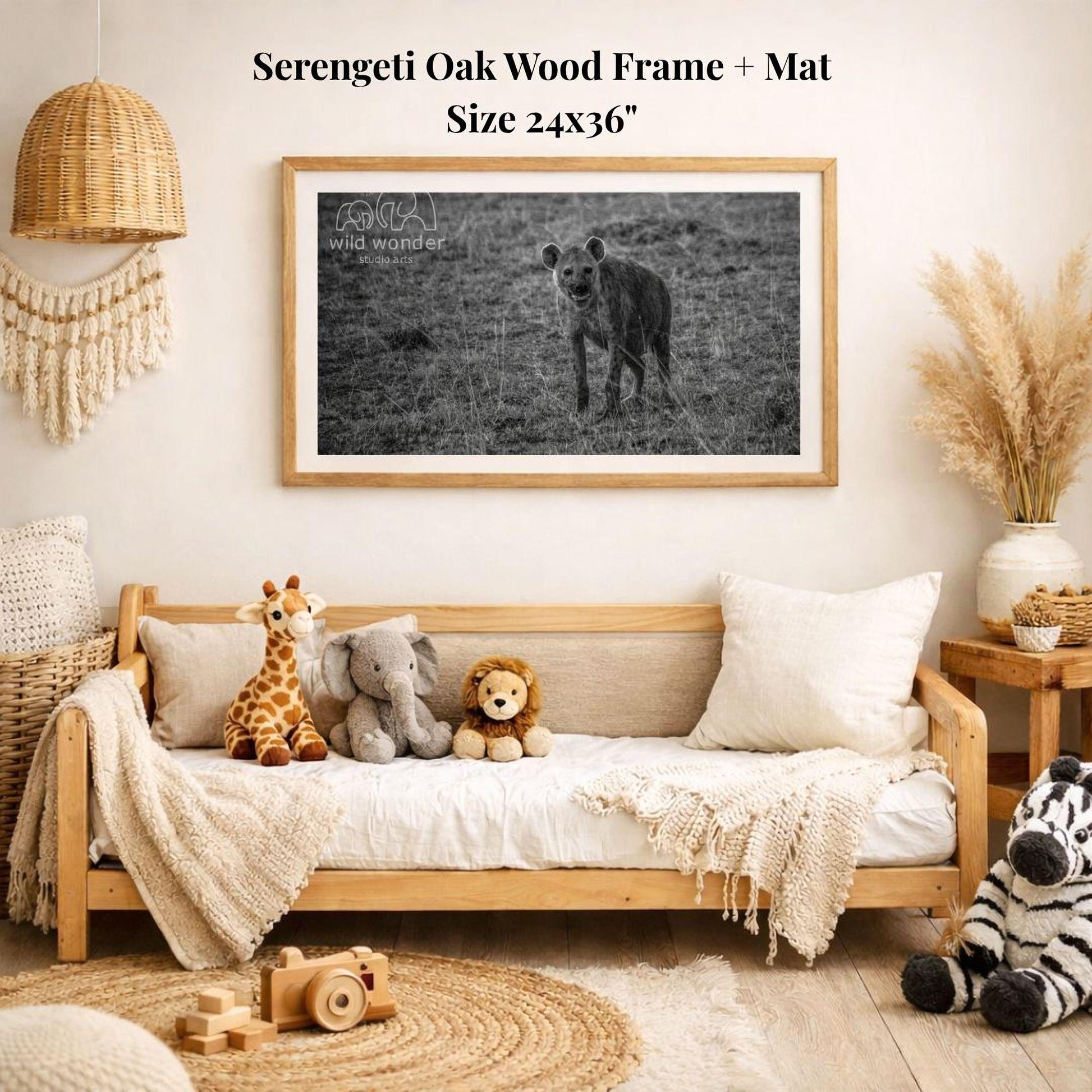 a serene indoor setting with a wooden frame and mat hanging on the wall, displaying a black and white photograph of a hyena in a grassy field. The frame is surrounded by various stuffed animals, including a giraffe, elephant, lion, and zebra, creating a cozy and playful atmosphere.