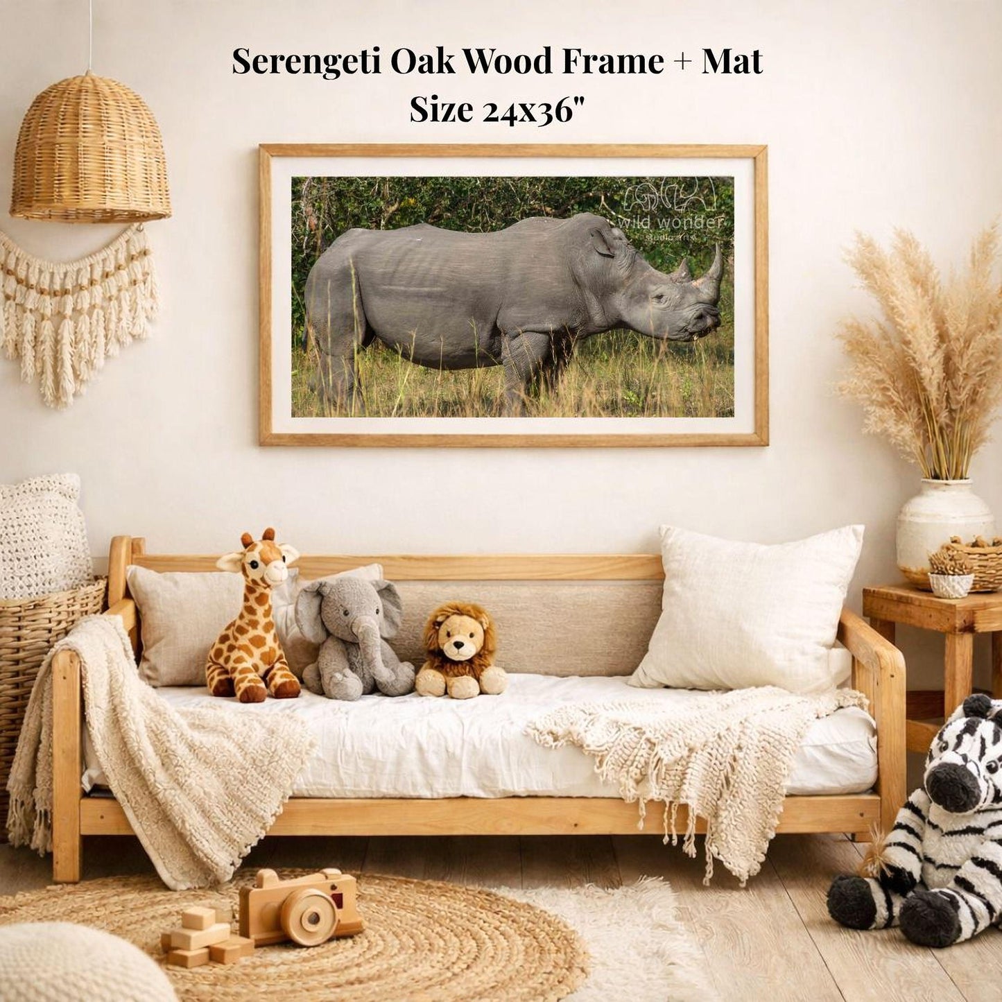 a serene indoor setting with a framed photograph of a rhinoceros, a giraffe, and an elephant on a white wall. The photograph is framed in a wooden frame and is hung above a wooden bench. The bench is adorned with stuffed animals, including a zebra and a lion. The room has a cozy and inviting atmosphere, with a rug and a potted plant adding to the overall aesthetic.