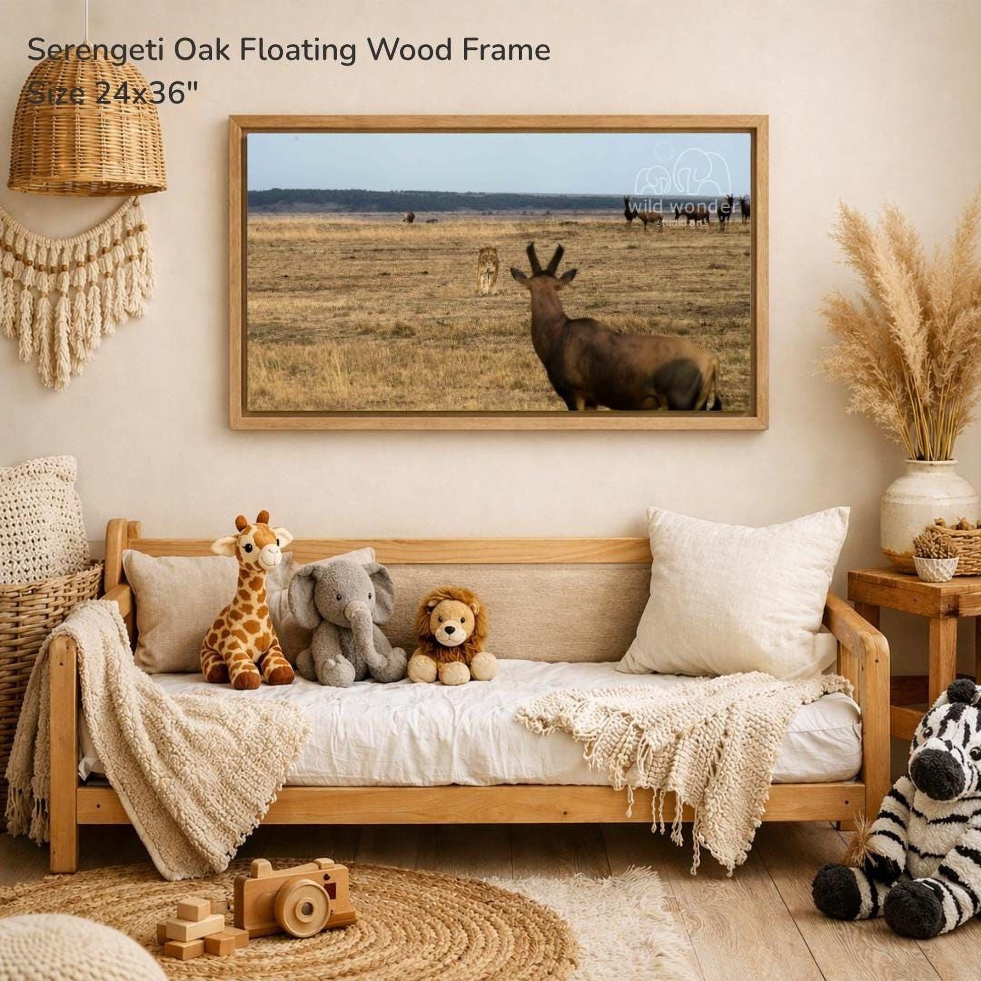 a serene indoor setting with a large framed photograph of a serene landscape hanging on the wall, depicting a serene field with a herd of wild animals. The photograph is framed in a wooden frame and is approximately 24 inches wide and 36 inches tall. The room is decorated with various items, including a wooden bench, a woven basket, and a stuffed animal, creating a cozy and inviting atmosphere.