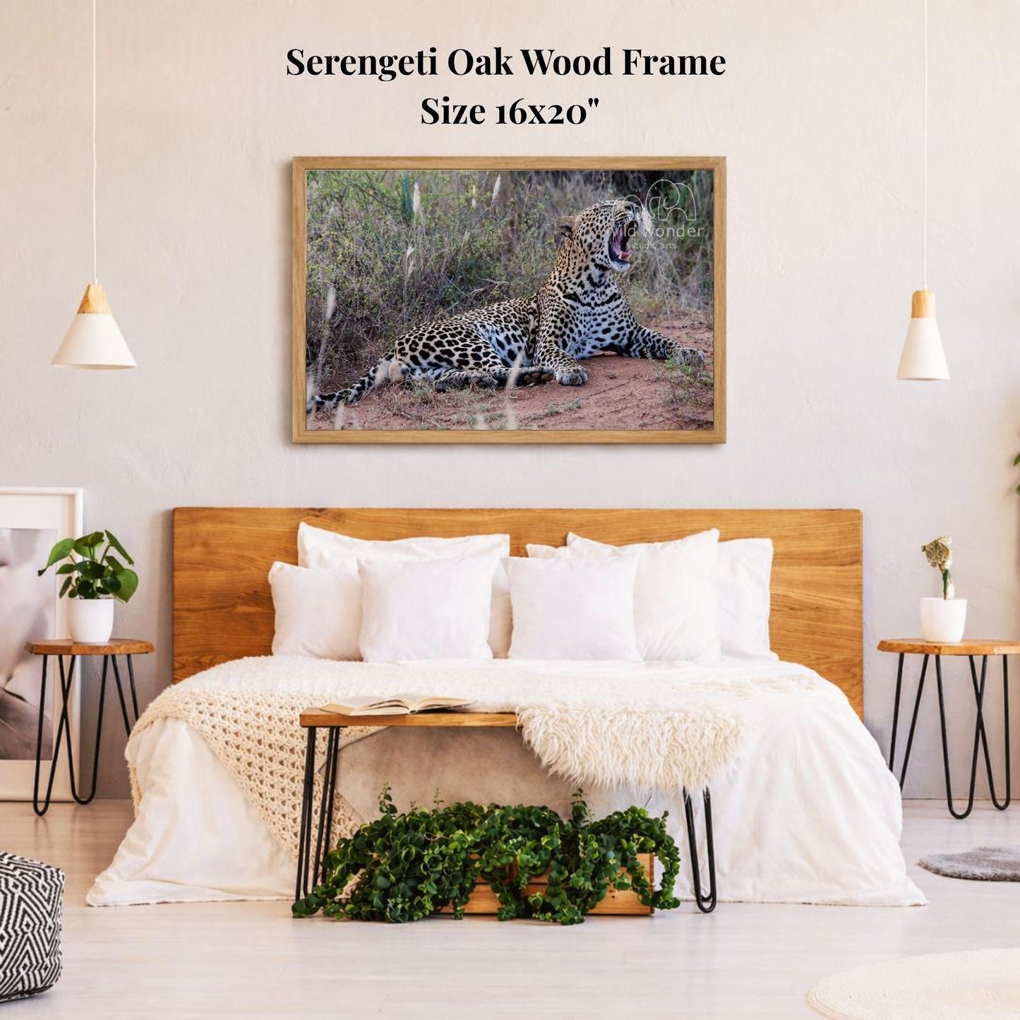a bedroom with a large framed photograph of a leopard resting on the wall above a bed with white bedding.