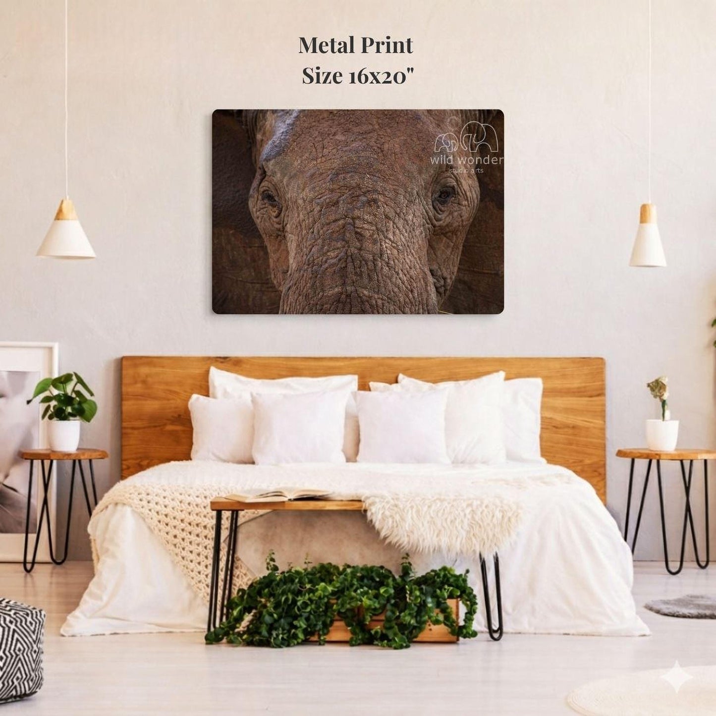 a large metal print of an elephant's face on a wall above a bed with white bedding and pillows.
