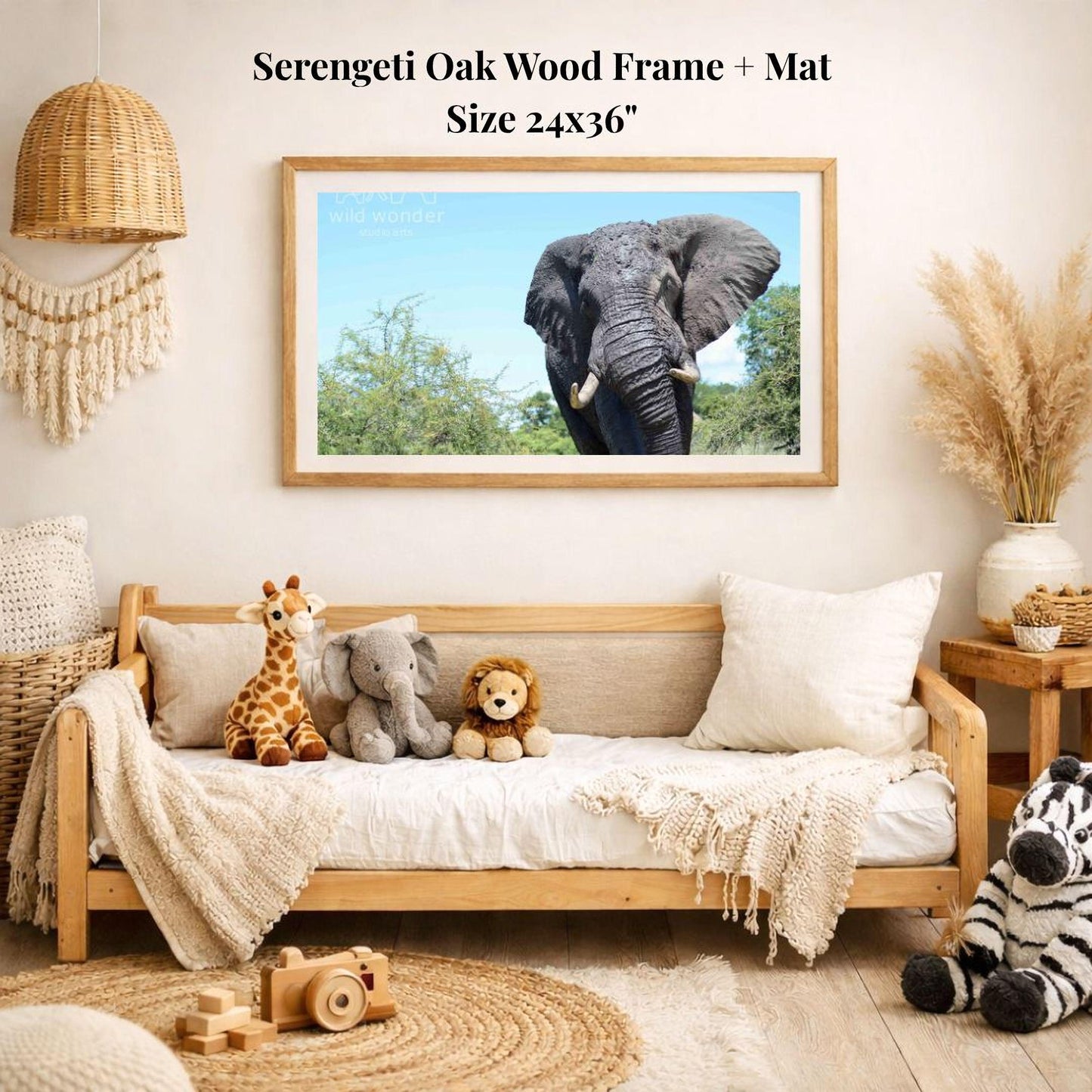 a serene indoor setting with a wooden frame and mat hanging on a wall, displaying a photograph of an elephant. The frame is surrounded by various stuffed animals, including a giraffe, an elephant, and a lion, creating a cozy and playful atmosphere.