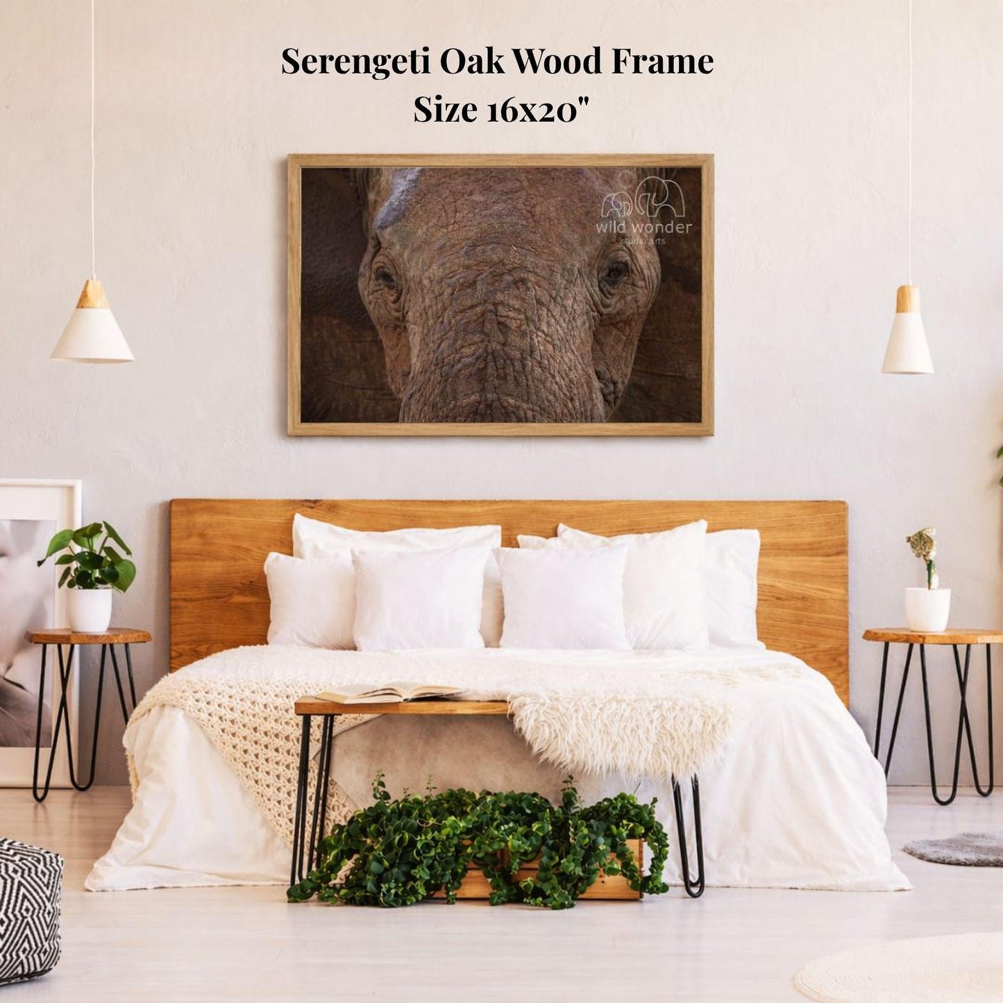 a serene bedroom setting with a large wooden headboard, a cozy bed with white bedding, and a framed photograph of a serene elephant on the wall above the bed.
