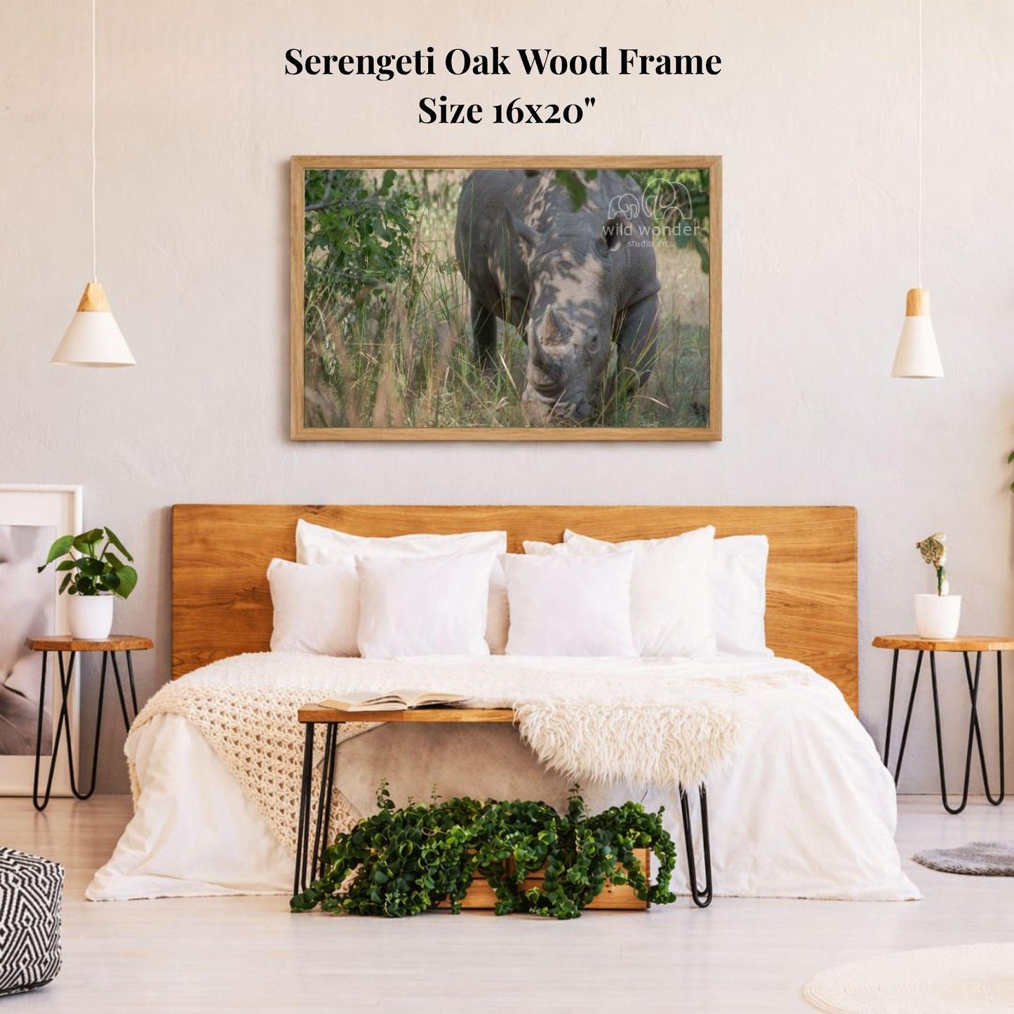 a serene bedroom setting with a large wooden headboard, a cozy bed with white bedding, and a framed photograph of a rhinoceros in a grassy field hanging above it.