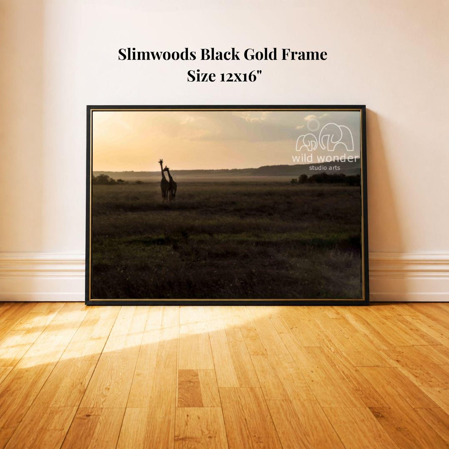A framed photograph of a giraffe standing in a grassy field at sunset, with the text "Slimwoods Black Gold Frame" and "Size 12x16" printed on the wall above the frame.