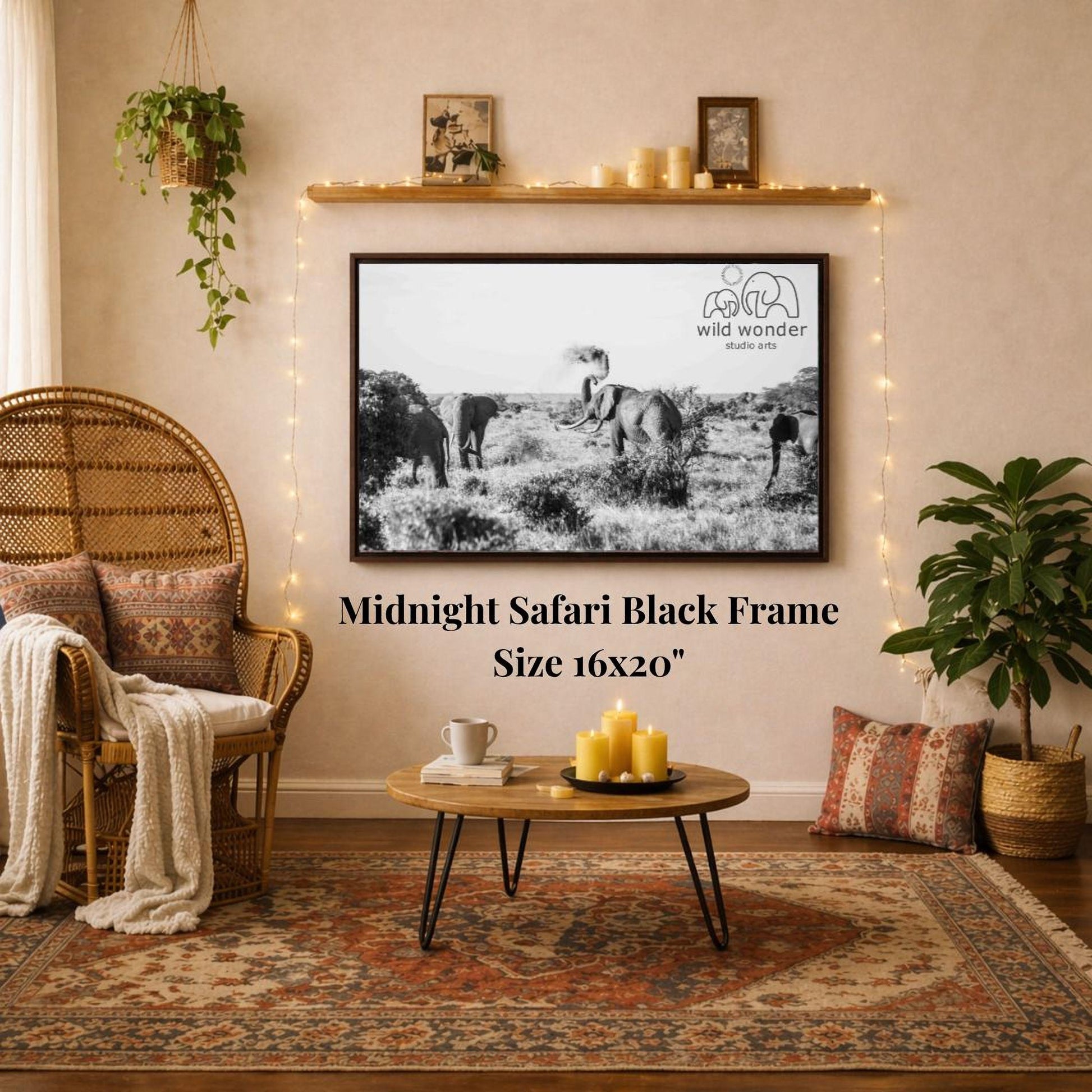 a living room with a large black and white photograph of elephants hanging on the wall. The photograph is framed in a 16x20" size. The room is decorated with a wicker chair, a coffee table, and a potted plant. The overall setting appears to be a cozy and comfortable living space.