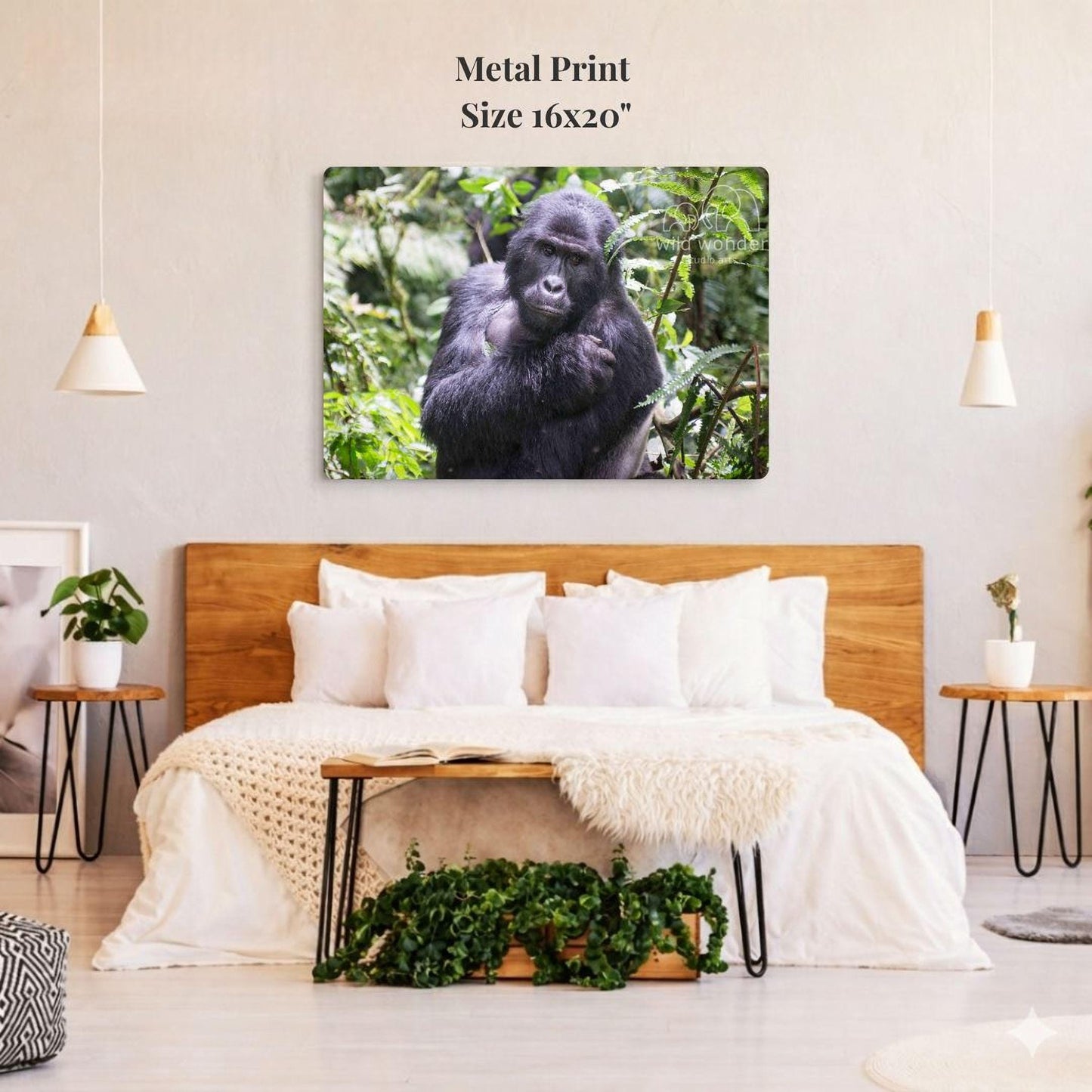 a bedroom with a large bed, wooden headboard, and a potted plant on a nightstand. Above the bed, there is a large metal print of a gorilla in a forest setting.
