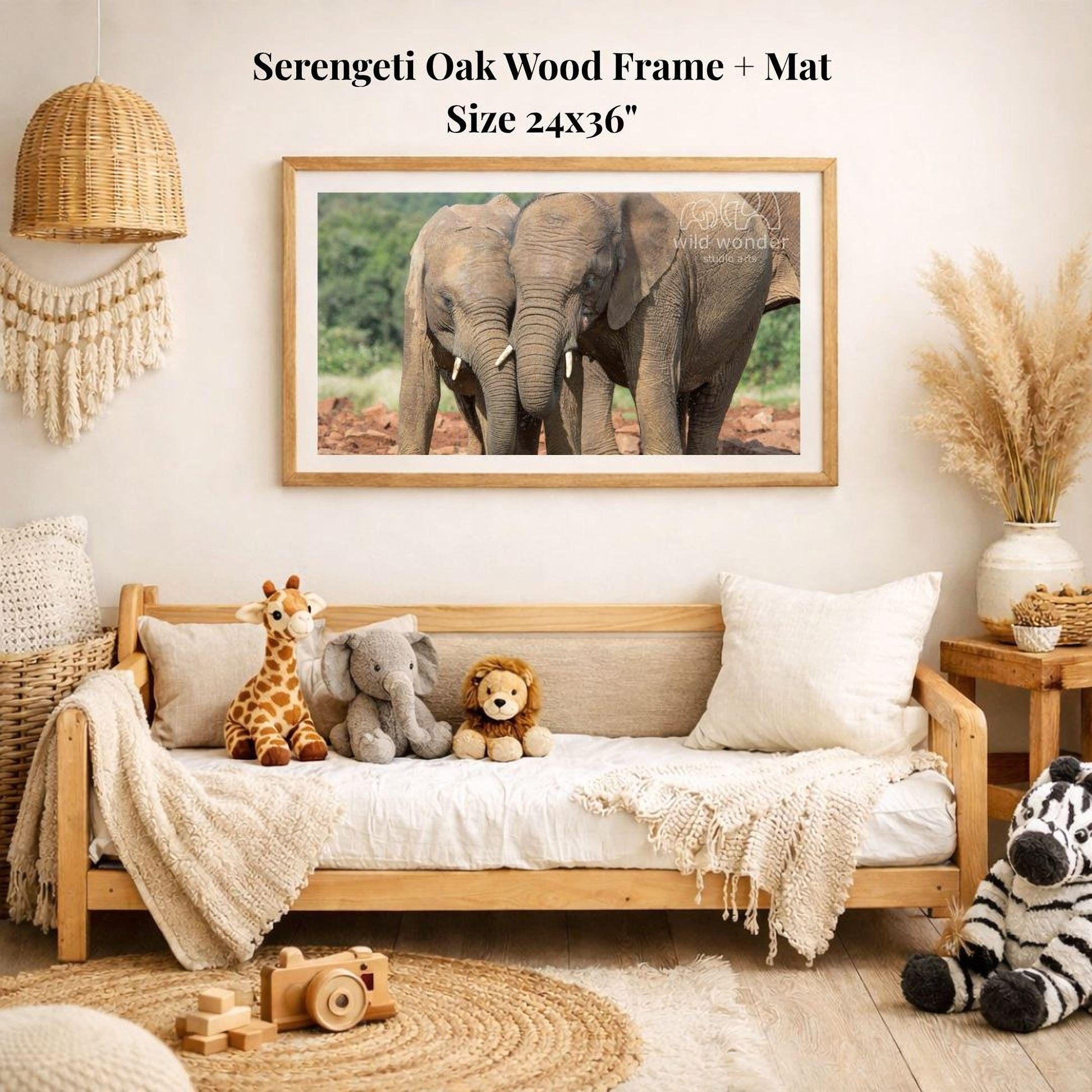 a serene indoor setting with a wooden frame and mat hanging on the wall, displaying a photograph of two elephants. The room is decorated with various stuffed animals, including a giraffe, lion, and zebra, arranged on a couch and a bed. A wooden toy camera is also present in the scene.