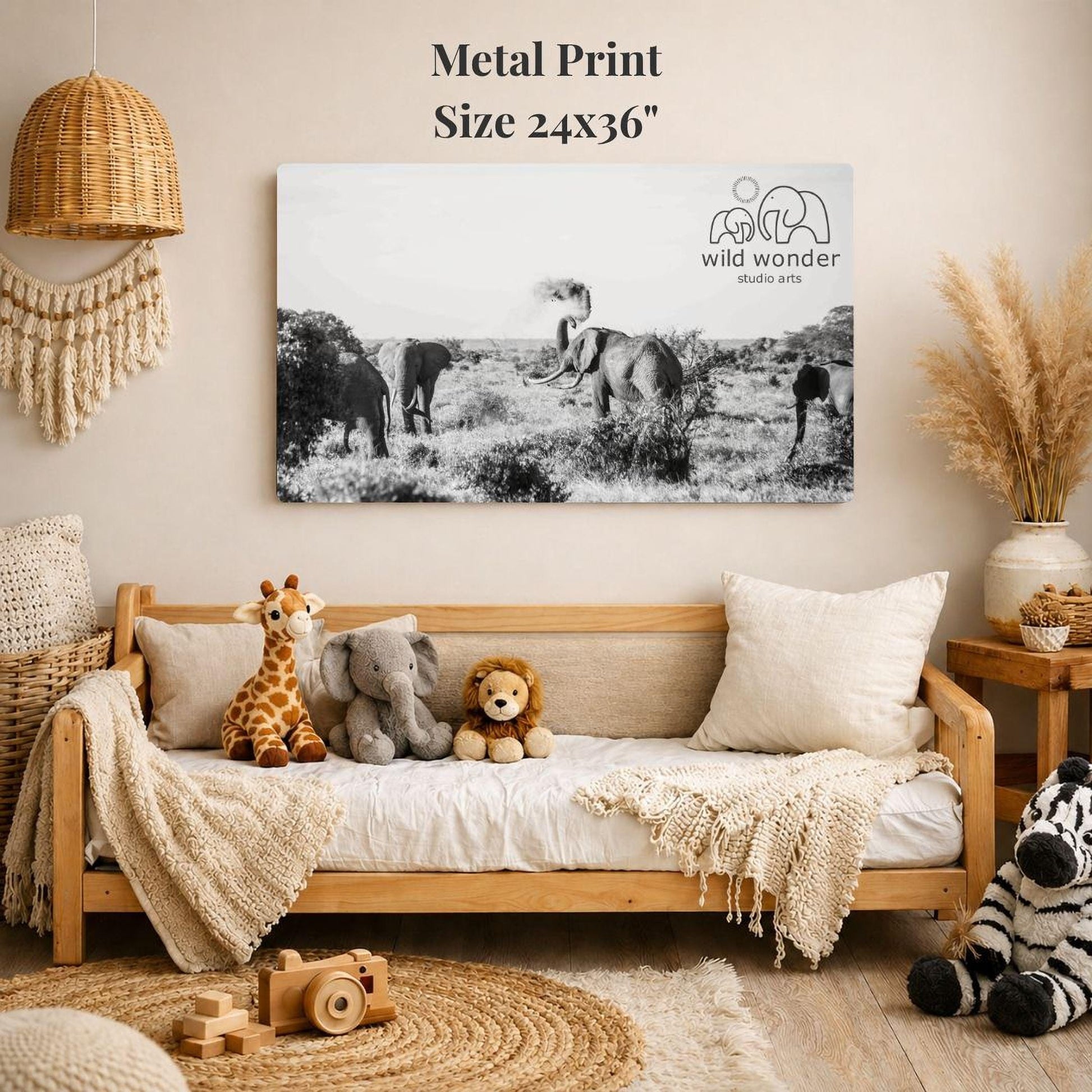 a cozy living room with a large black and white photograph of elephants and other wildlife displayed on the wall. The photograph is framed in metal and measures 24x36 inches. The room is decorated with various items, including a woven basket, a wooden chair, a stuffed giraffe, a stuffed lion, and a stuffed zebra. The overall scene conveys a sense of warmth and comfort, with the natural elements of the wildlife photograph complementing the homely atmosphere created by the furnishings and decor.