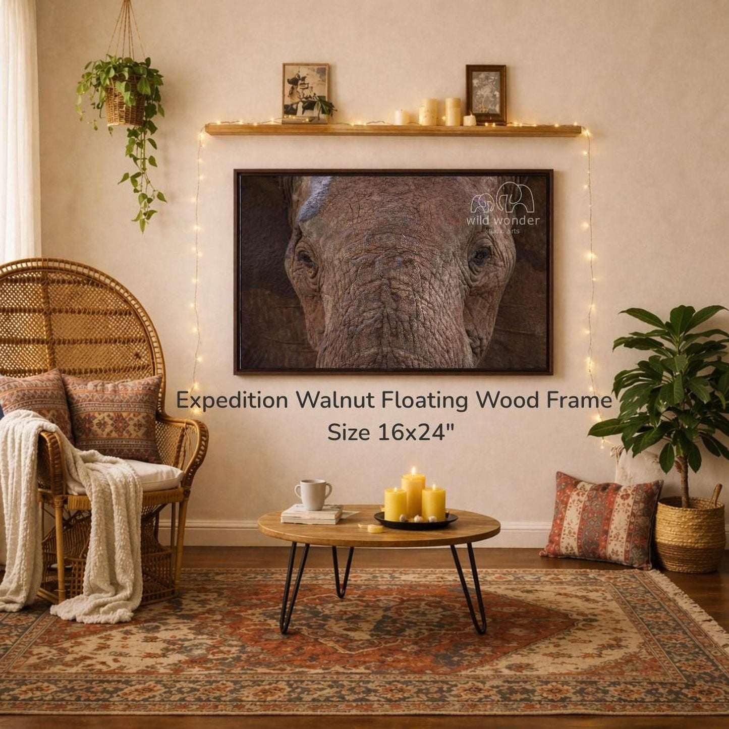 a large, 16x24" wood frame hanging on a wall, with a painting of an elephant displayed above it. The room has a cozy, rustic atmosphere with a wicker chair, a coffee table, and a potted plant. The overall scene appears to be a living room or a similar space with a focus on the wooden frame and the elephant painting.