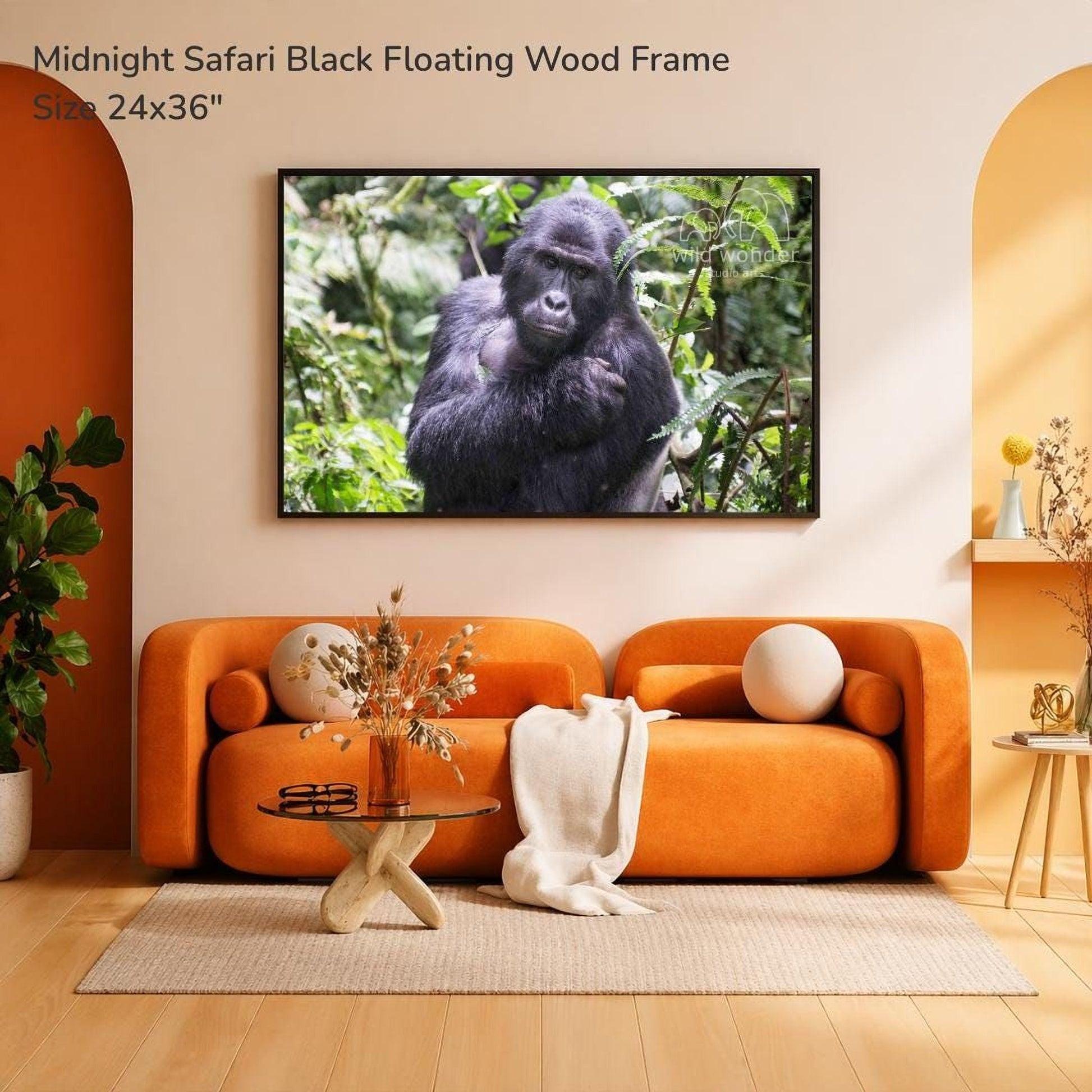 a large black gorilla sitting in a lush, green forest environment, mounted on a wall above a cozy living room setting with an orange sofa, a glass coffee table, and a potted plant.