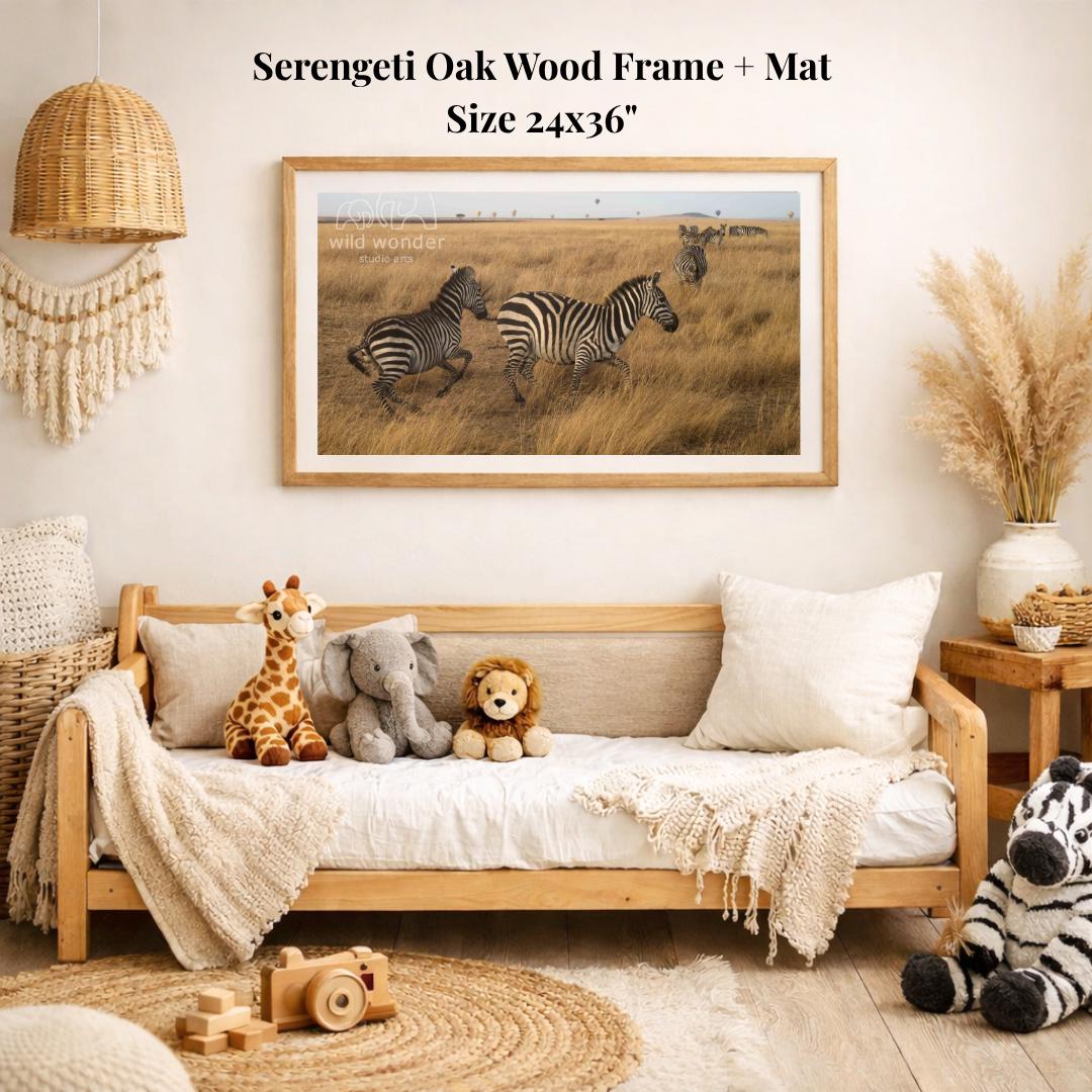 a serene indoor setting with a wooden frame and mat hanging on a wall, displaying a photograph of two zebras in a grassy field. The room is decorated with various items, including a wooden bench, a woven basket, a potted plant, and a stuffed animal.