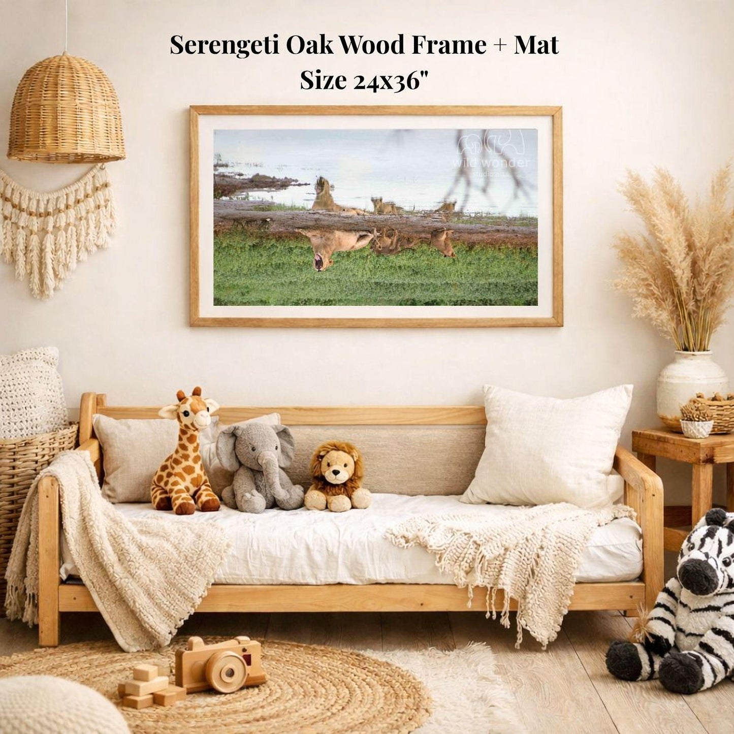 a serene indoor setting with a wooden frame and mat hanging on a wall, displaying a photograph of a group of animals in a grassy field. The frame is surrounded by various stuffed animals, including a giraffe, elephant, lion, and zebra, creating a cozy and playful atmosphere.