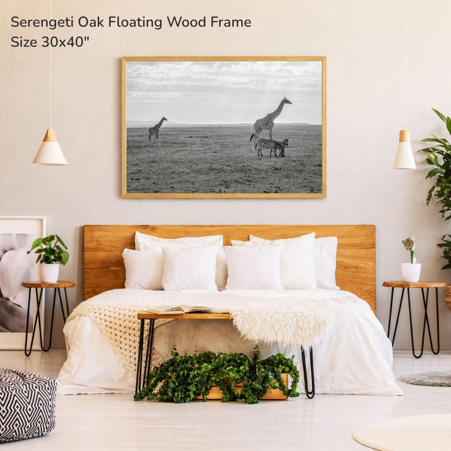 a serene bedroom setting with a large wooden headboard and a cozy bed. Above the bed, there is a framed photograph of two giraffes and a zebra in a savanna-like environment. The room is decorated with potted plants and other natural elements, creating a calming and peaceful atmosphere.