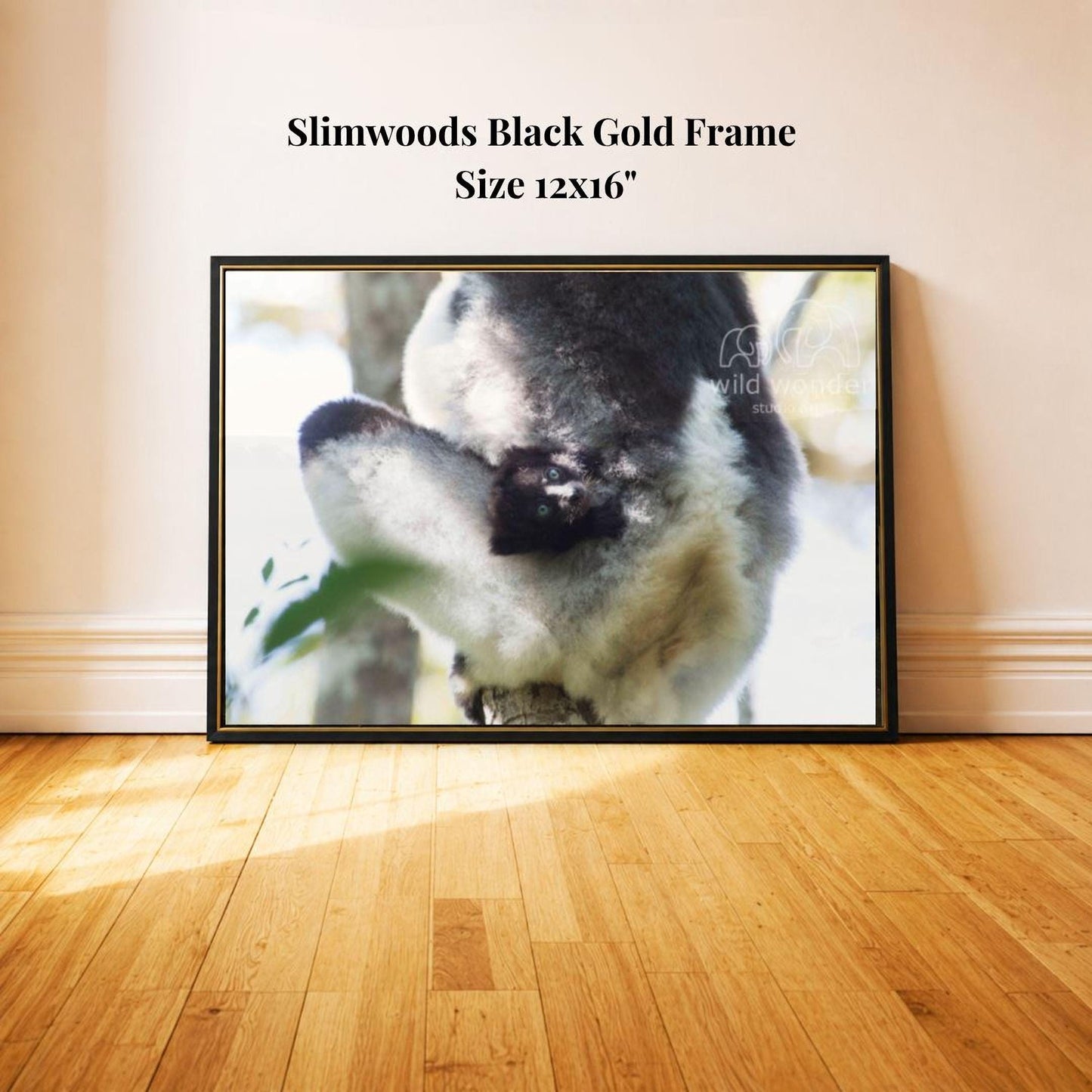 A framed photograph of a lemur, a type of primate, is displayed on a wooden floor against a white wall.