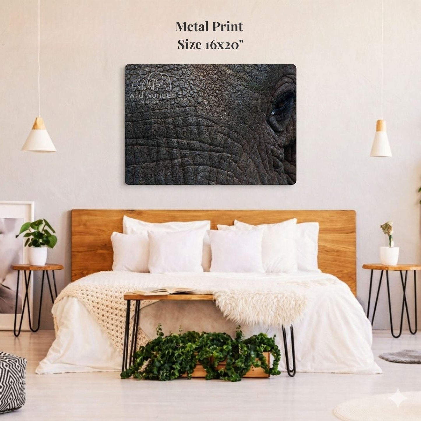 a large metal print of an elephant's eye on a wall above a bed with white bedding and a wooden headboard.