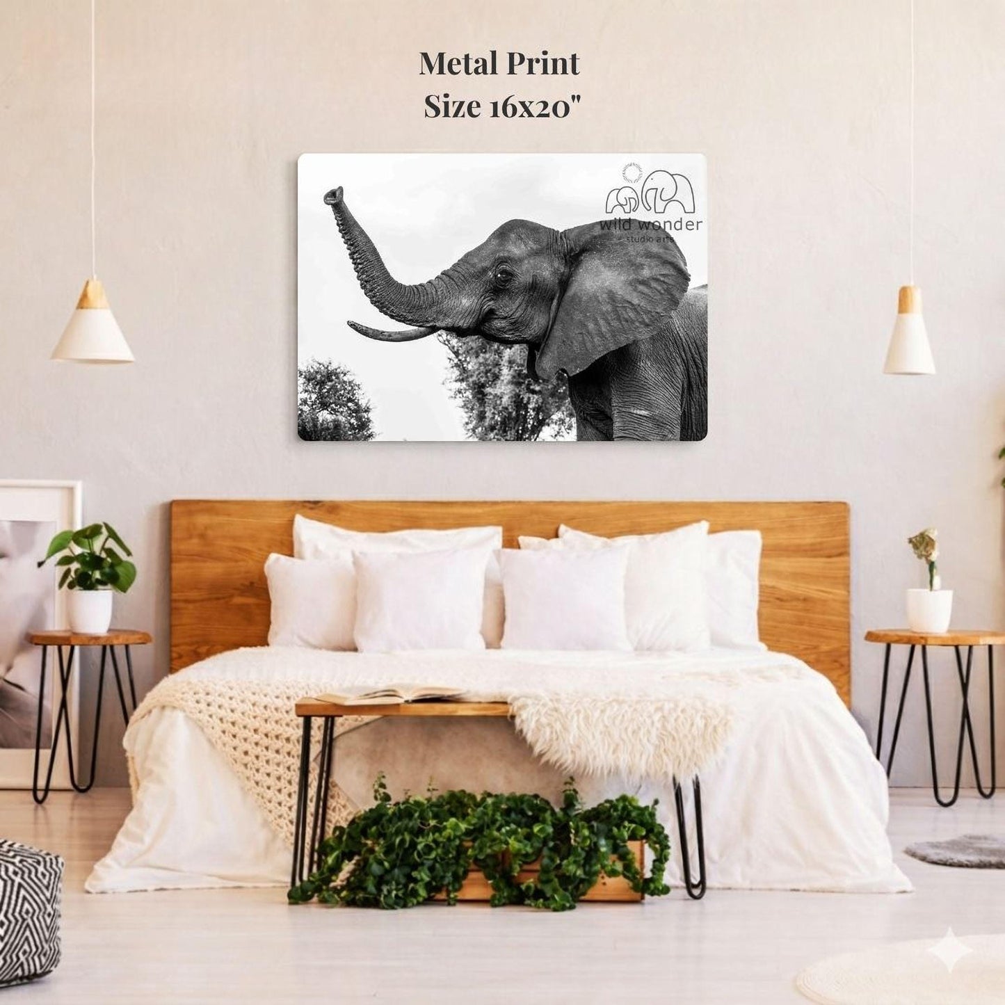 a large metal print of an elephant on a wall above a bed with white bedding and pillows.