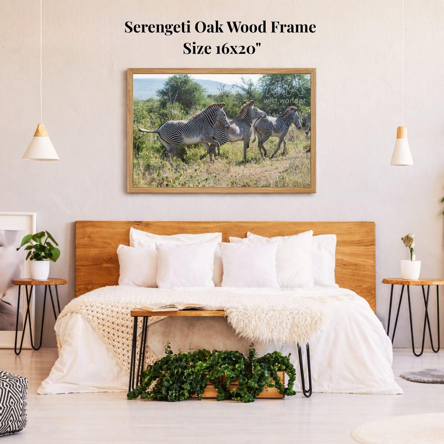 a serene bedroom scene with a large framed photograph of zebras in the background, hanging on the wall above a bed with white bedding.