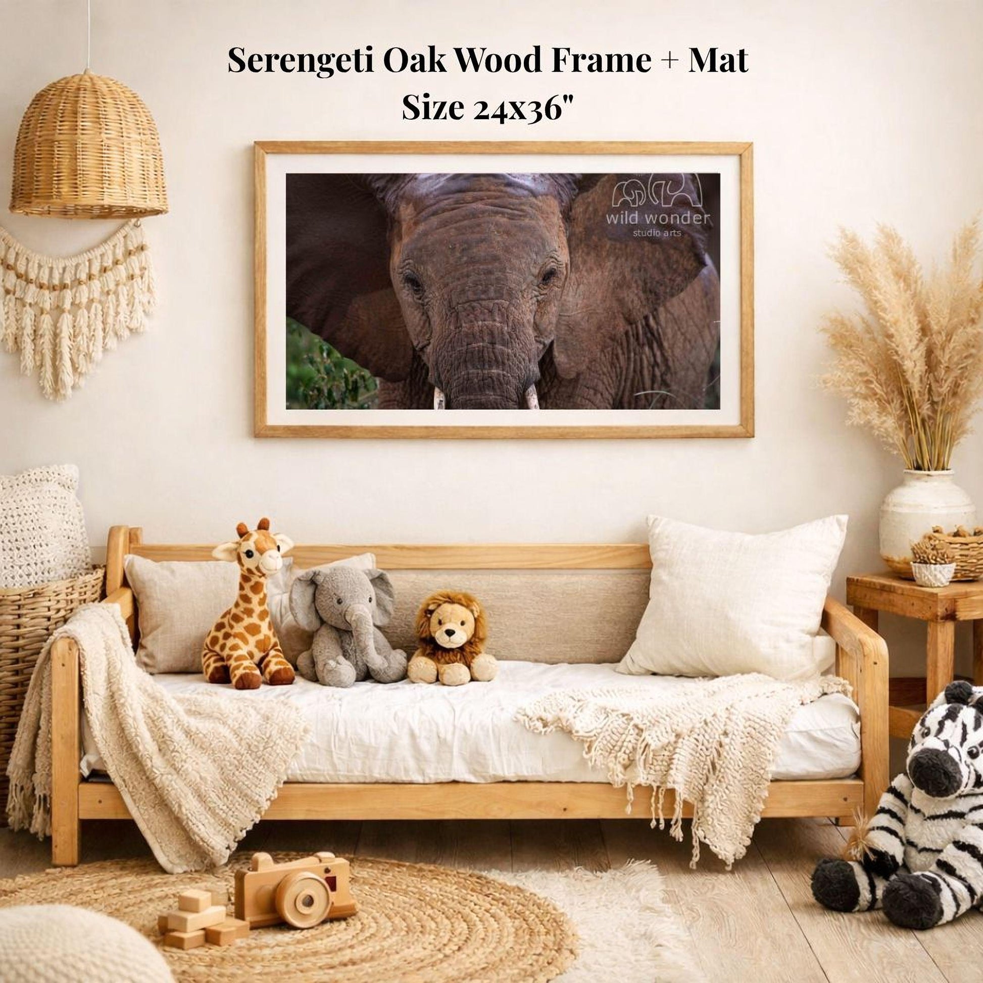 a serene indoor setting with a wooden frame and mat hanging on the wall, displaying a photograph of an elephant. The room is decorated with various stuffed animals, including a giraffe, elephant, lion, and zebra, arranged on a couch and a rug. The overall scene conveys a sense of warmth and comfort, with the wooden frame and mat adding a touch of rustic charm to the space.