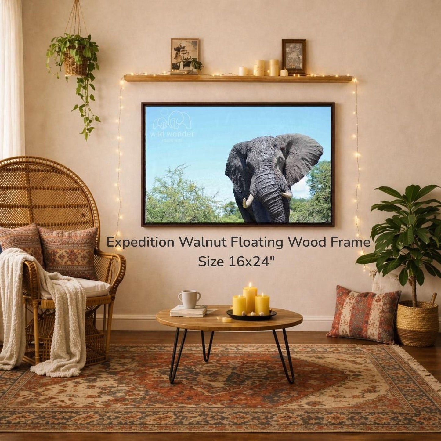 a large, 16x24" wood frame hanging on a wall, with a picture of an elephant displayed on it. The room has a cozy, rustic atmosphere with a wicker chair, a coffee table, and a potted plant. The overall scene appears to be a living room or a den, with a focus on the wooden frame and the elephant image.