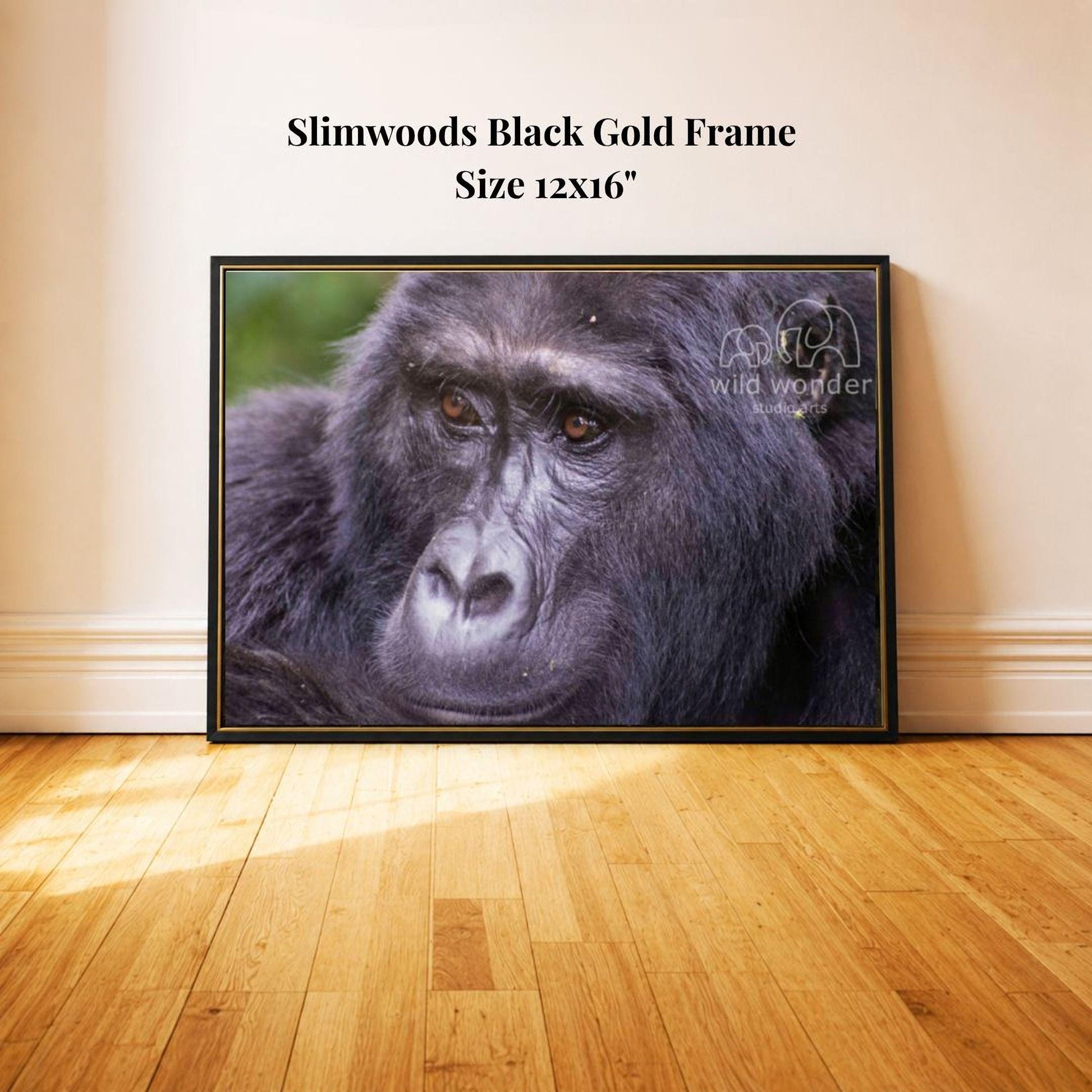 A close-up of a gorilla's face in a black gold frame, with a wooden floor in the background.