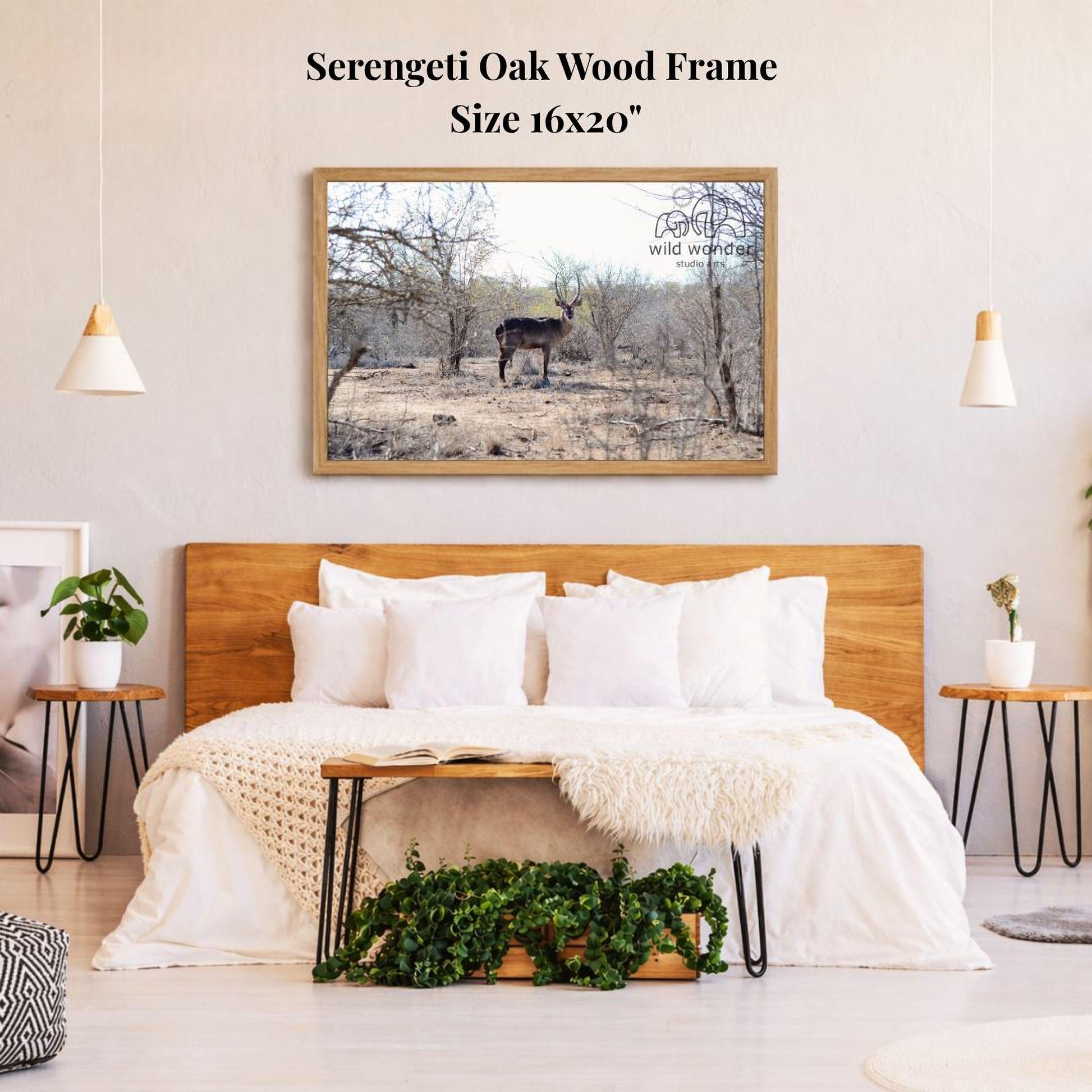 a serene bedroom scene with a large framed picture of a deer standing in a field, hanging on the wall above a bed with white bedding.