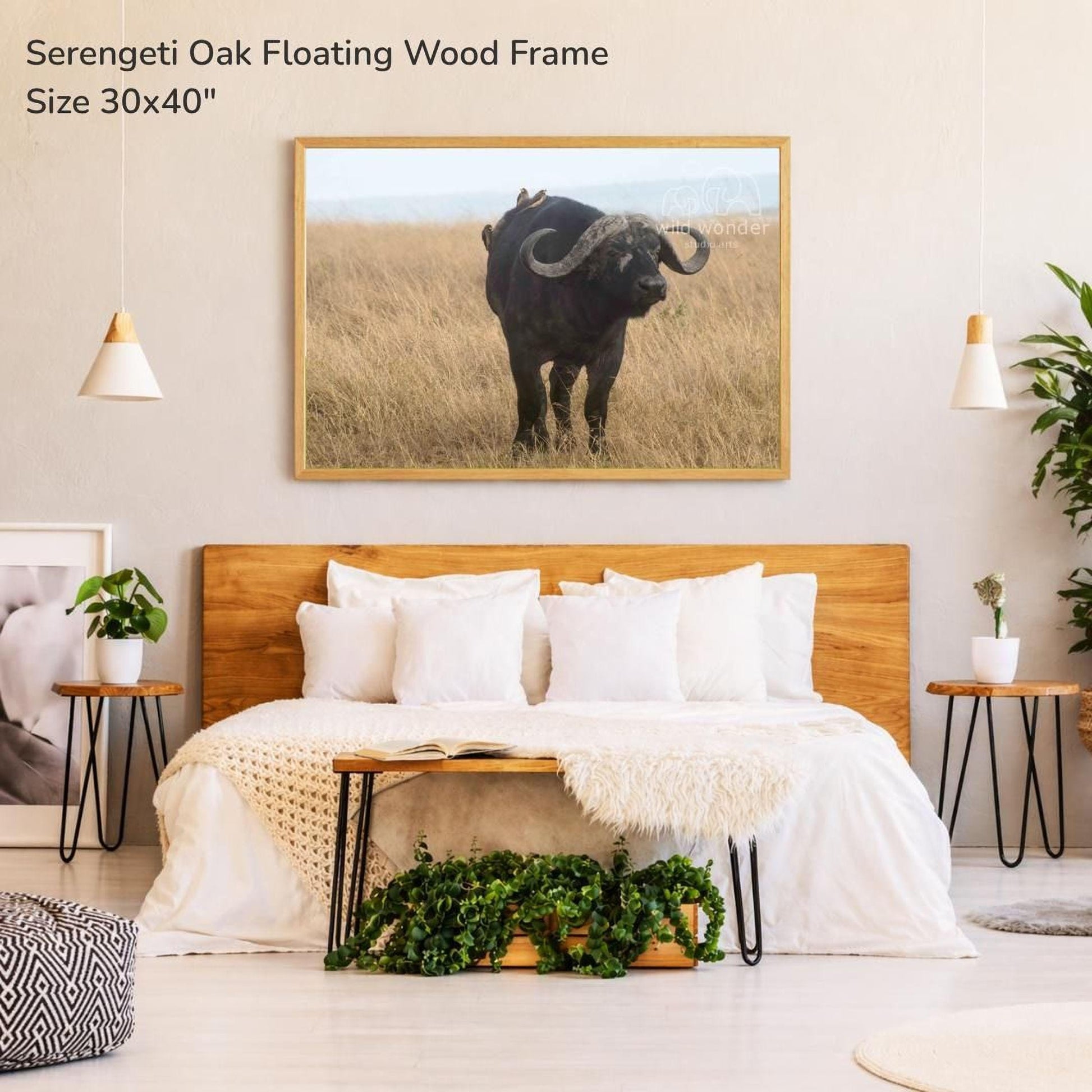 a bedroom with a large bed, a wooden headboard, and a framed photograph of a horned animal, likely a buffalo or a bison, hanging on the wall above the bed.