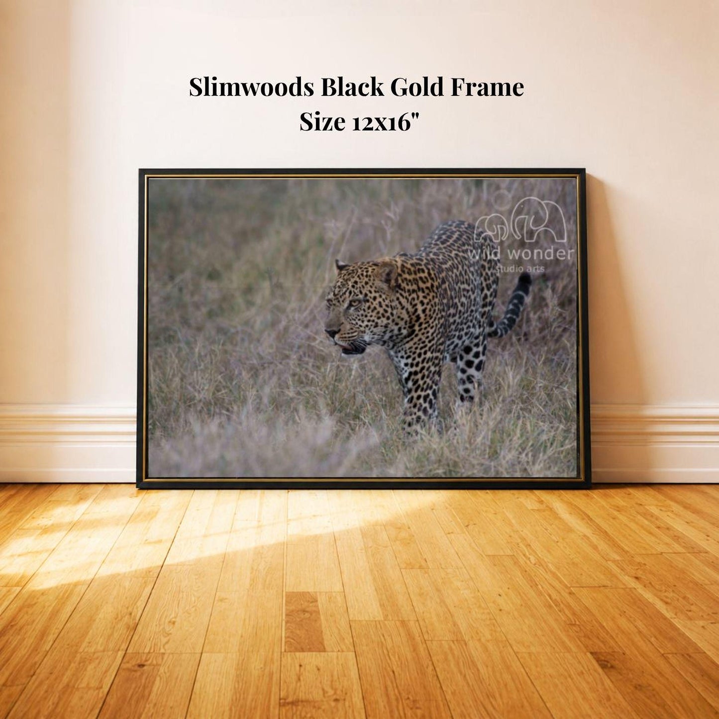 A framed photograph of a leopard standing in tall grass, with a black frame and text indicating the size of the frame as 12x16 inches.