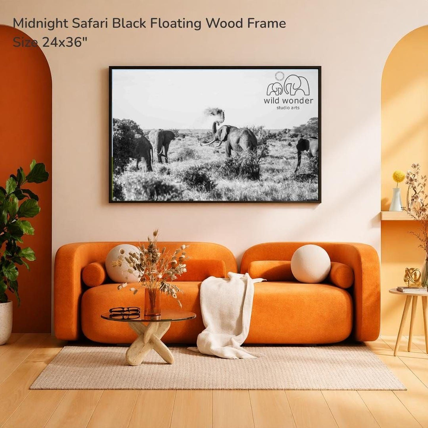 a modern living room with an orange sofa, a glass coffee table, and a framed black and white photograph of elephants in a savannah landscape hanging on the wall.