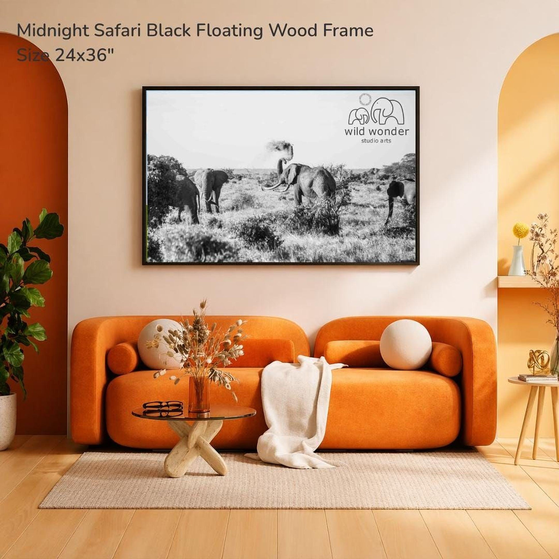 a modern living room with an orange sofa, a glass coffee table, and a framed black and white photograph of elephants in a savannah landscape hanging on the wall.