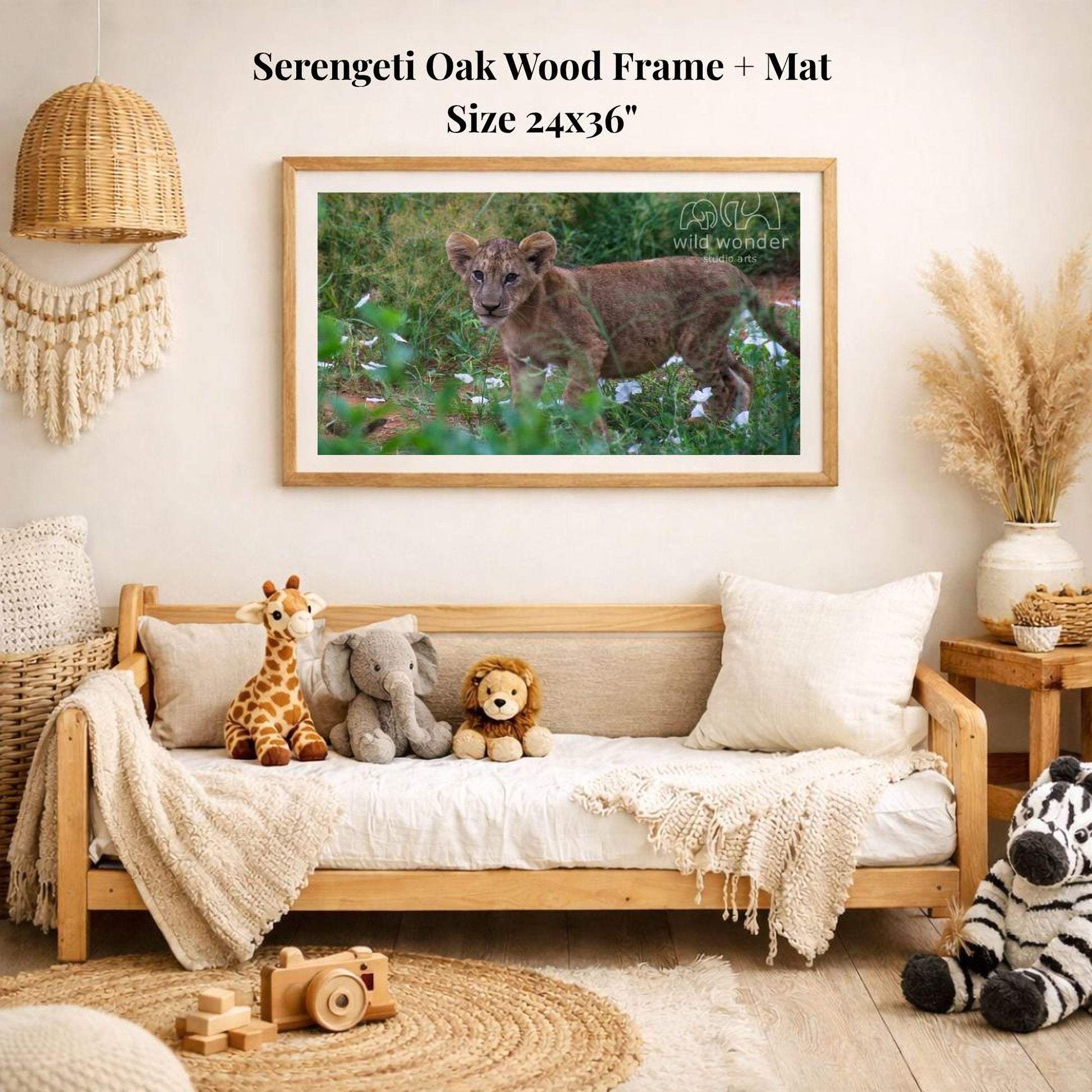 a serene indoor setting with a wooden frame and mat hanging on a wall, displaying a photograph of a young lion cub in a grassy field. The room is decorated with various stuffed animals, including a giraffe, elephant, lion, and zebra, arranged on a couch and a rug.
