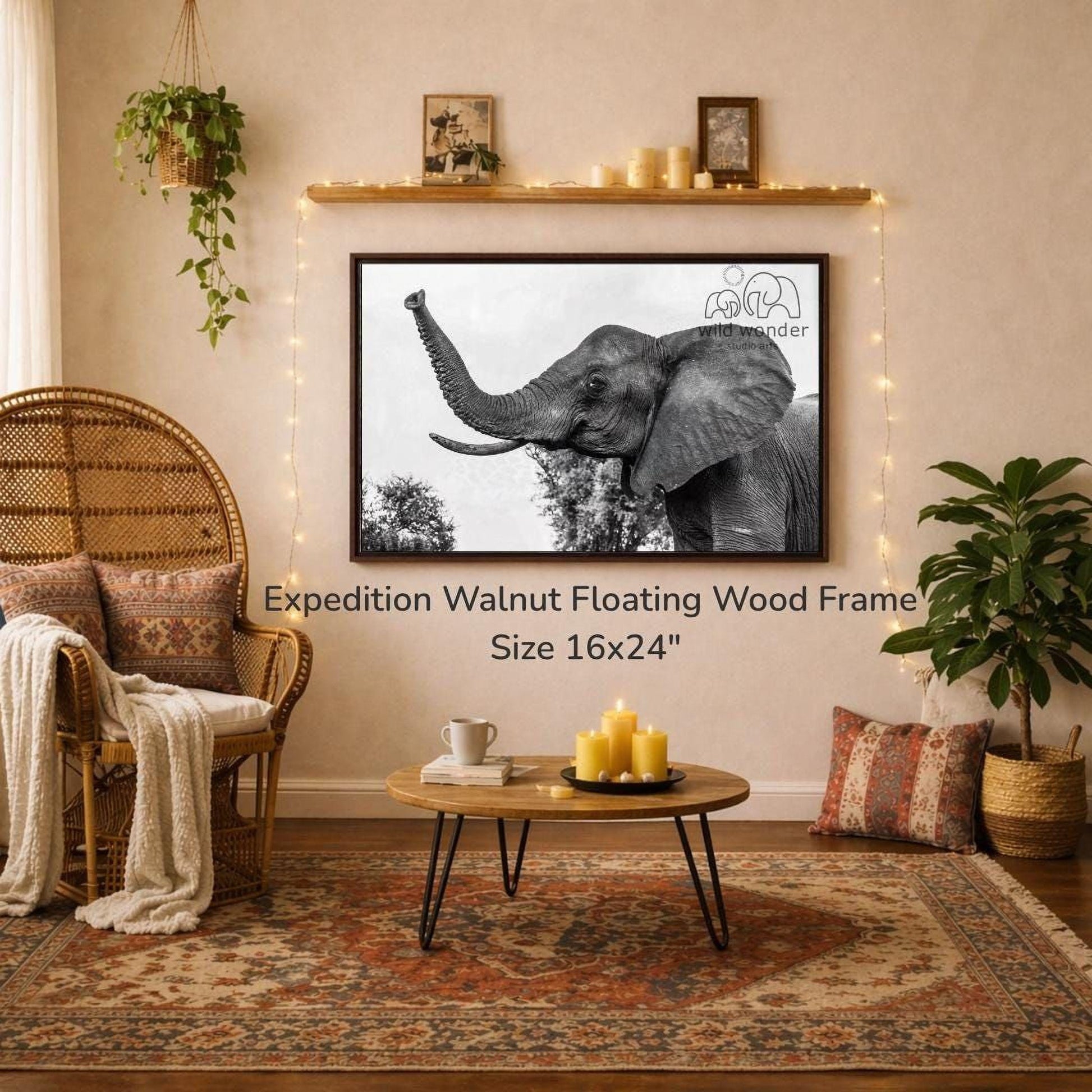 a large black and white photograph of an elephant, hanging on a wall above a coffee table in a cozy living room setting.