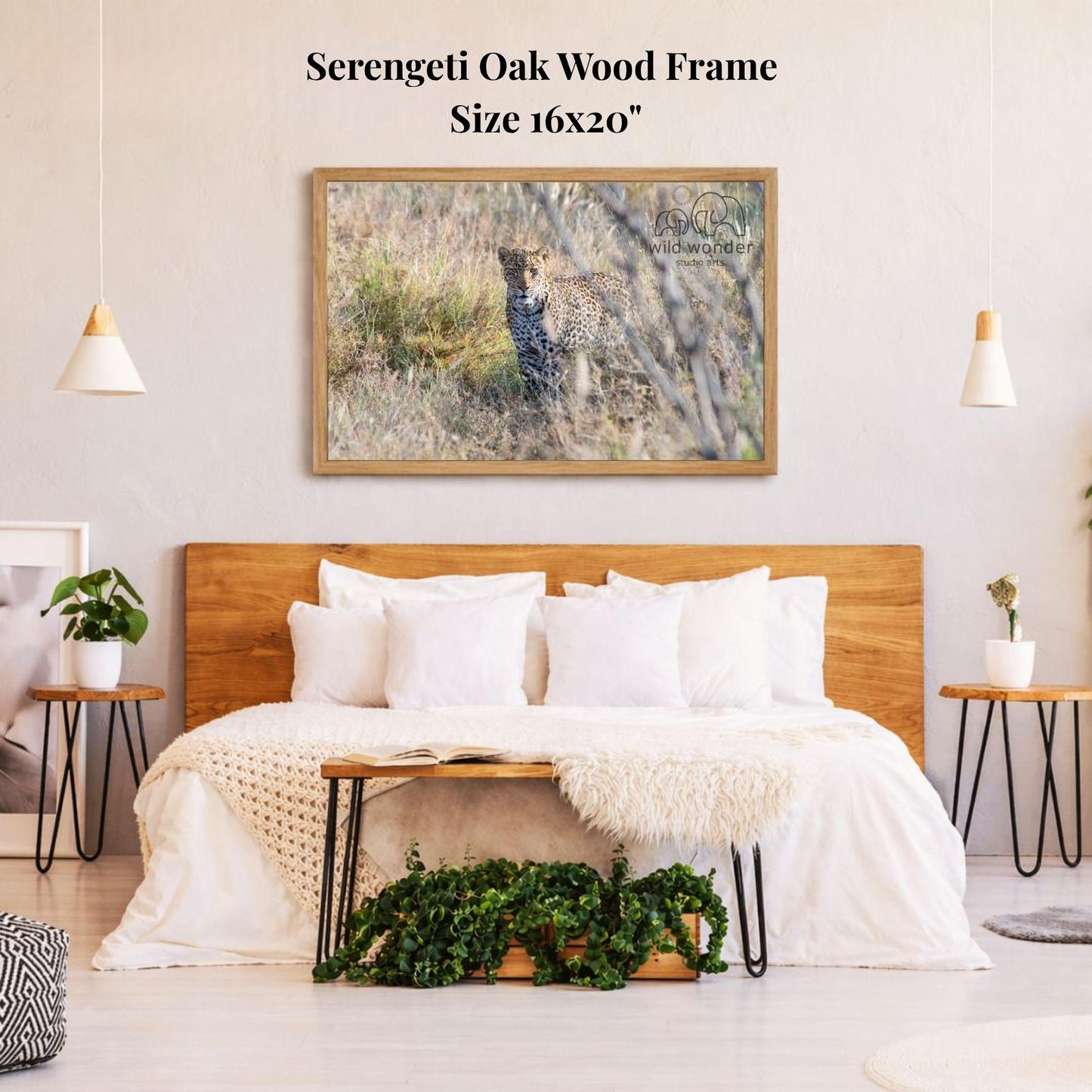 a serene bedroom setting with a large framed picture of a leopard resting in the grass on the wall above a bed with white bedding.