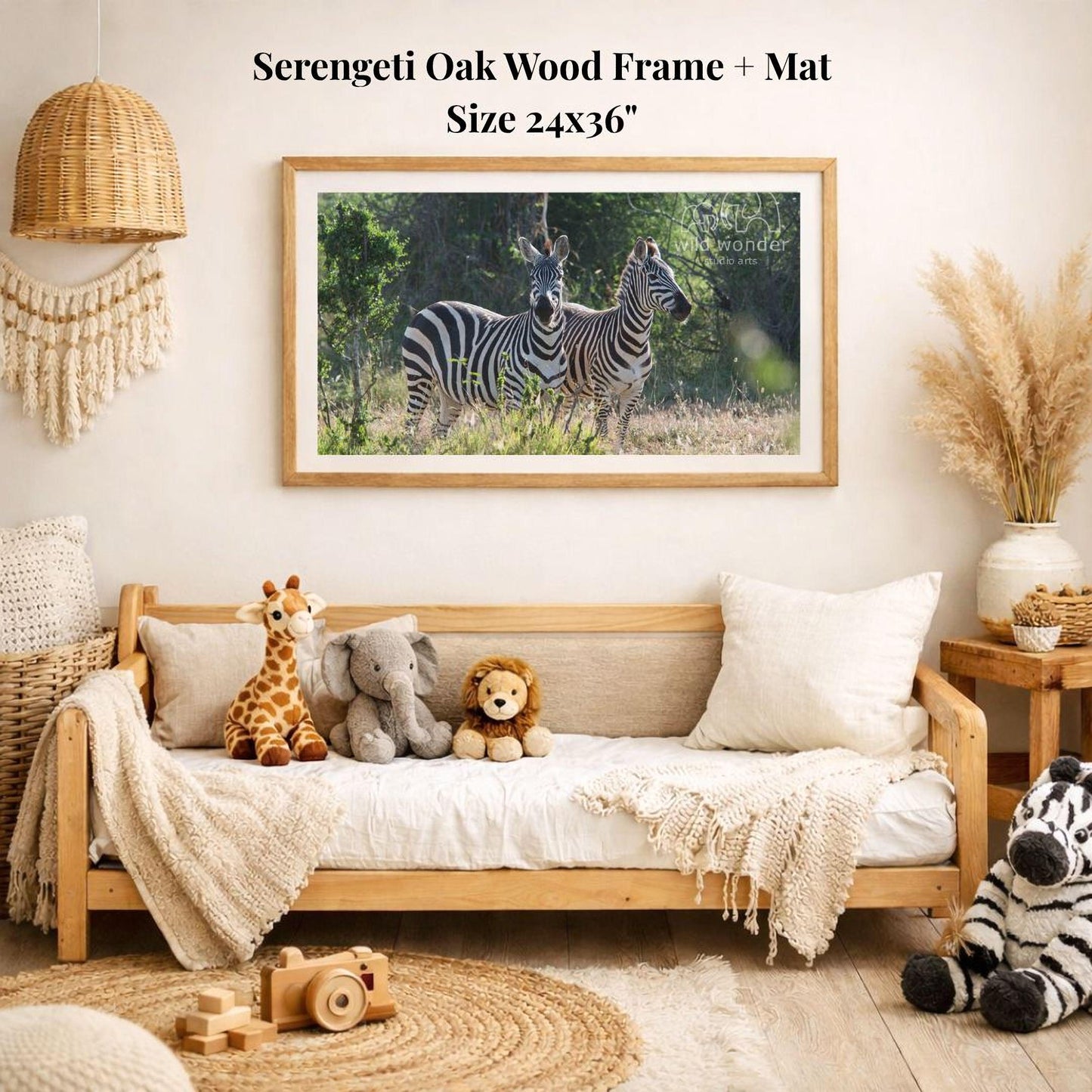a serene indoor setting with a wooden frame and mat hanging on the wall, displaying a photograph of two zebras in a grassy field. The room is decorated with various stuffed animals, including a giraffe, elephant, lion, and zebra, arranged on a couch and a rug. The overall scene conveys a sense of warmth and comfort, with the natural elements of the zebras and the playful presence of the stuffed animals creating a harmonious and inviting atmosphere.
