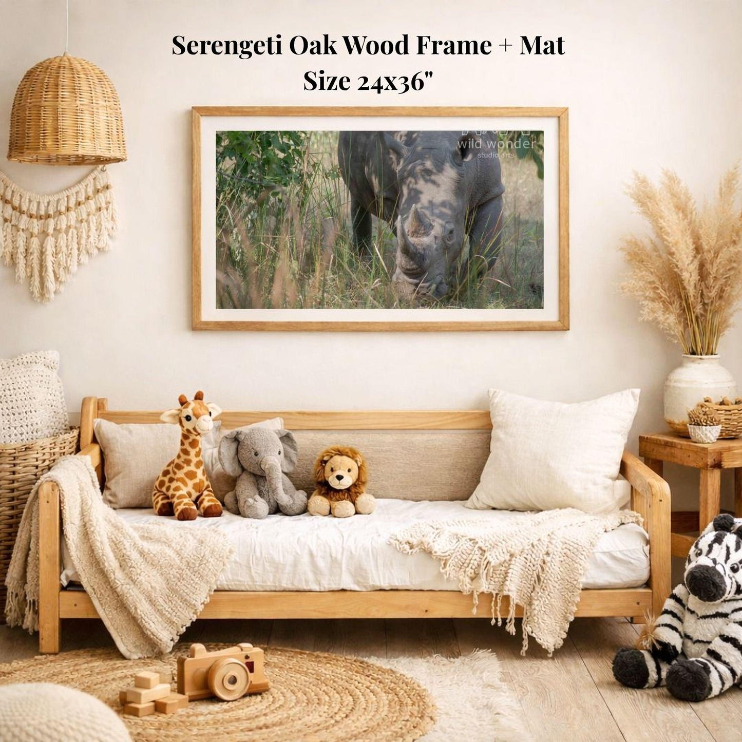 a serene indoor setting with a wooden frame and mat hanging on the wall, displaying a photograph of a rhinoceros in a grassy field. The frame is surrounded by various stuffed animals, including a giraffe, elephant, lion, and zebra, creating a cozy and playful atmosphere.