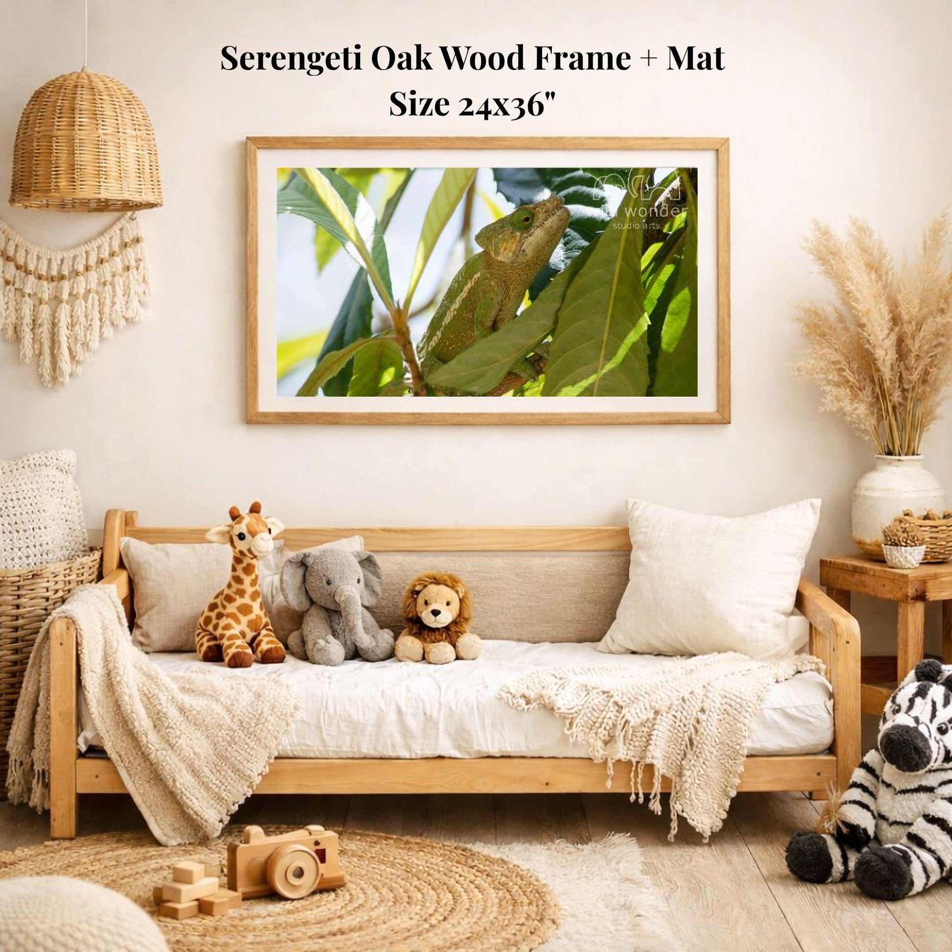 a serene indoor setting with a wooden frame and mat hanging on a wall, displaying a photograph of a chameleon on a branch. The frame is surrounded by a variety of stuffed animals, including a giraffe, elephant, lion, and zebra, arranged on a couch. The room also includes a woven basket, a potted plant, and a wooden toy car, creating a cozy and playful atmosphere.