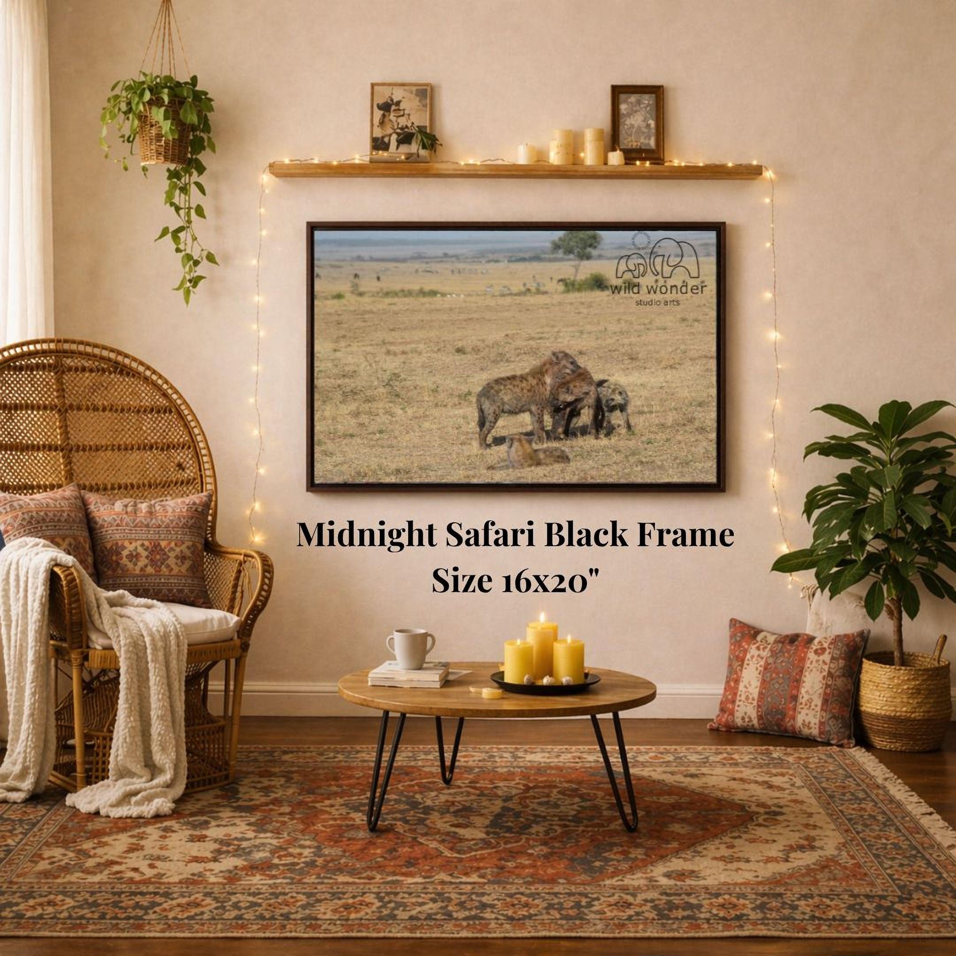 a living room with a large framed photograph of two elephants in a savanna scene hanging on the wall. The photograph is mounted on a black frame, and the text "Midnight Safari Black Frame" is displayed below it. The room also includes a wicker chair, a coffee table, and various decorative elements such as a potted plant and a woven basket.