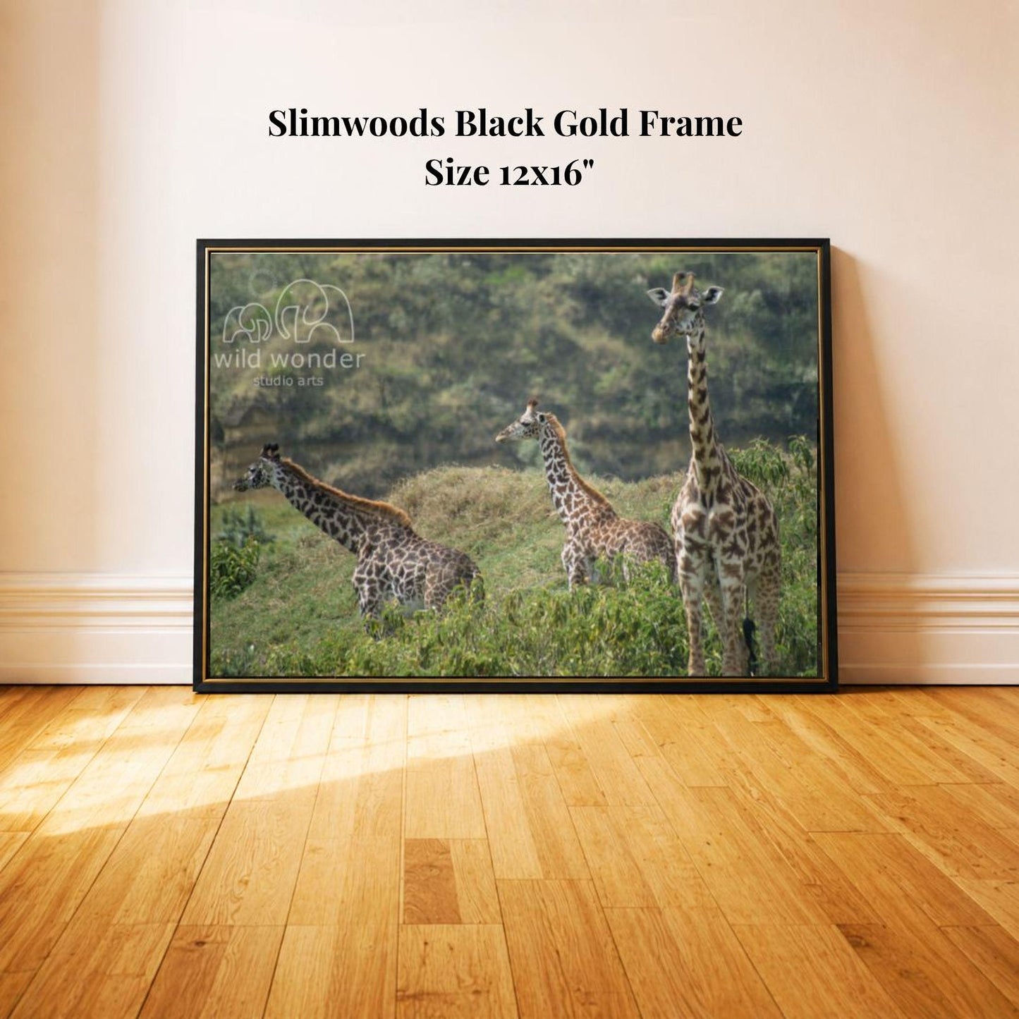 A framed photograph of three giraffes in a grassy field, with a black gold frame.