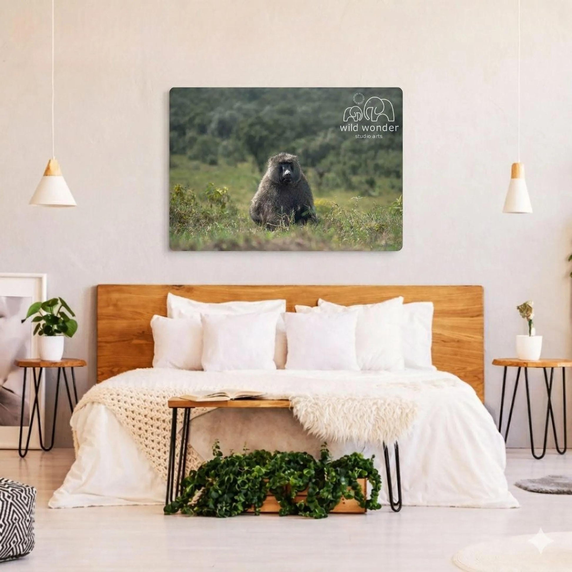 a bedroom with a large metal print of a bear sitting in the grass on the wall. The bedroom has a wooden headboard and a white bedding set. There are also two potted plants and a small table in the room.