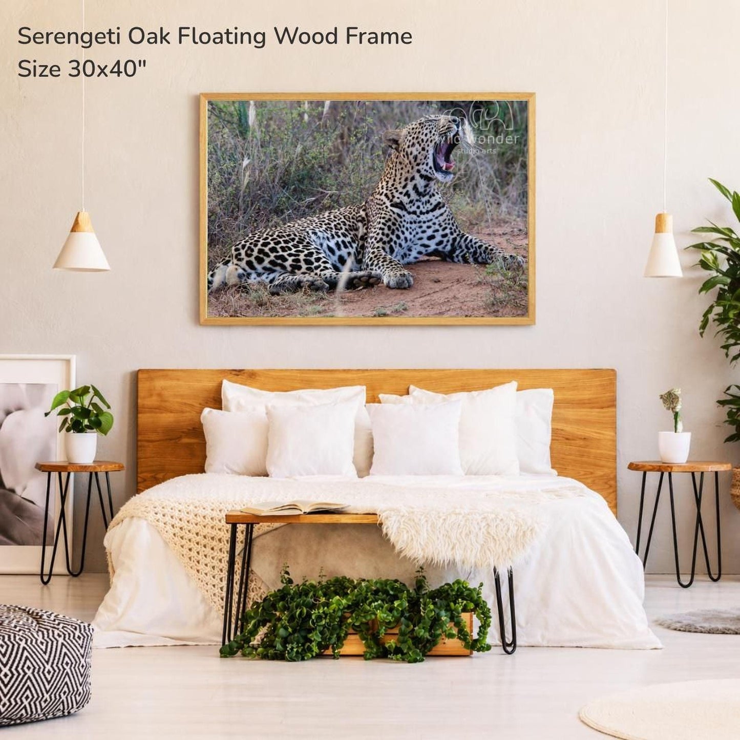 a bedroom with a large framed photograph of a leopard resting on the wall above a bed with white bedding.